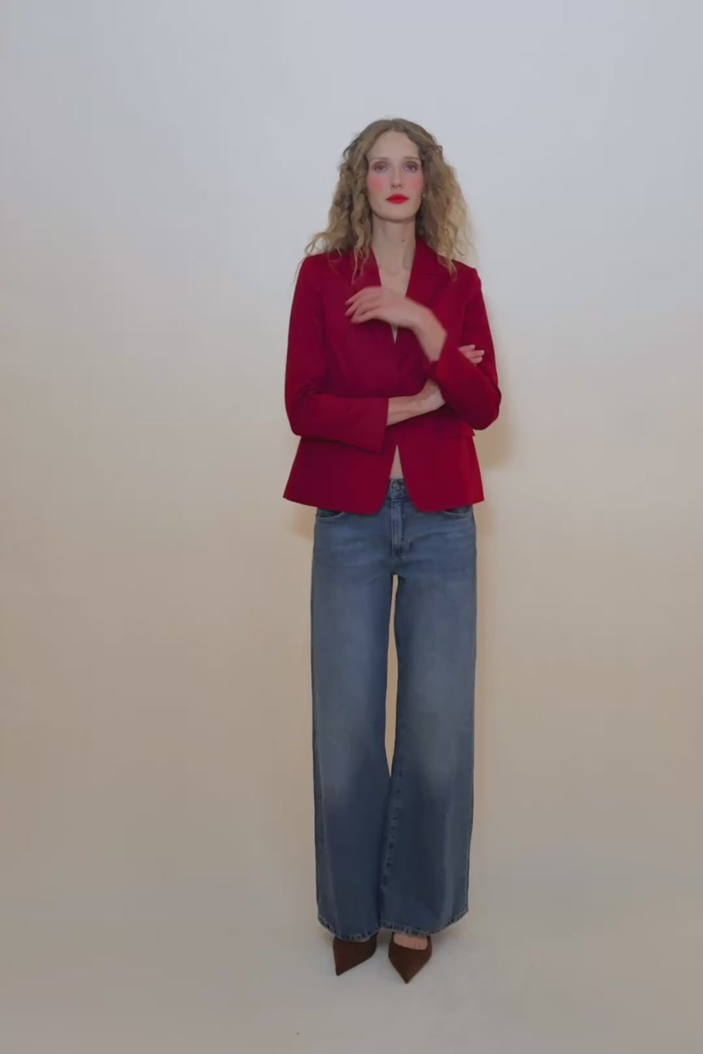 woman in red blazer and blue jeans.