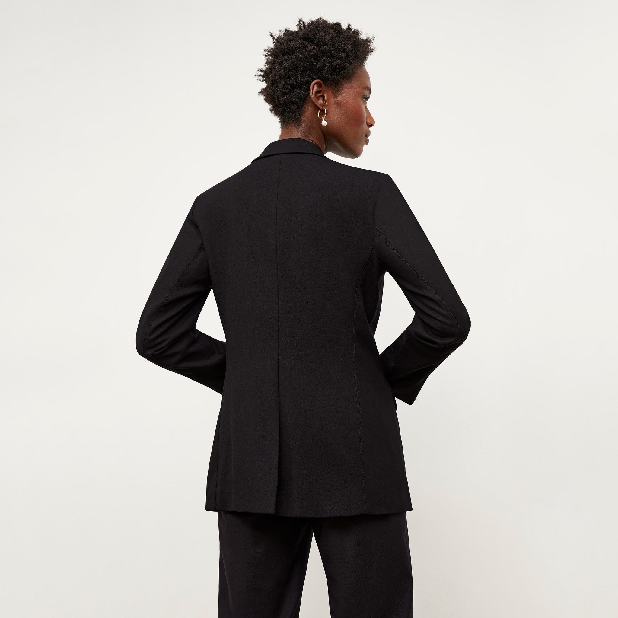 Back image of a woman standing wearing the Yiyan Blazer in Black