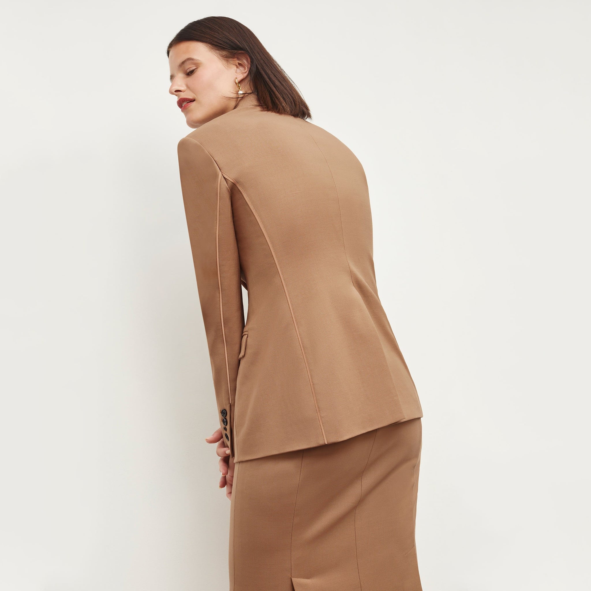 Back image of a woman standing wearing the Yiyan Blazer in Camel