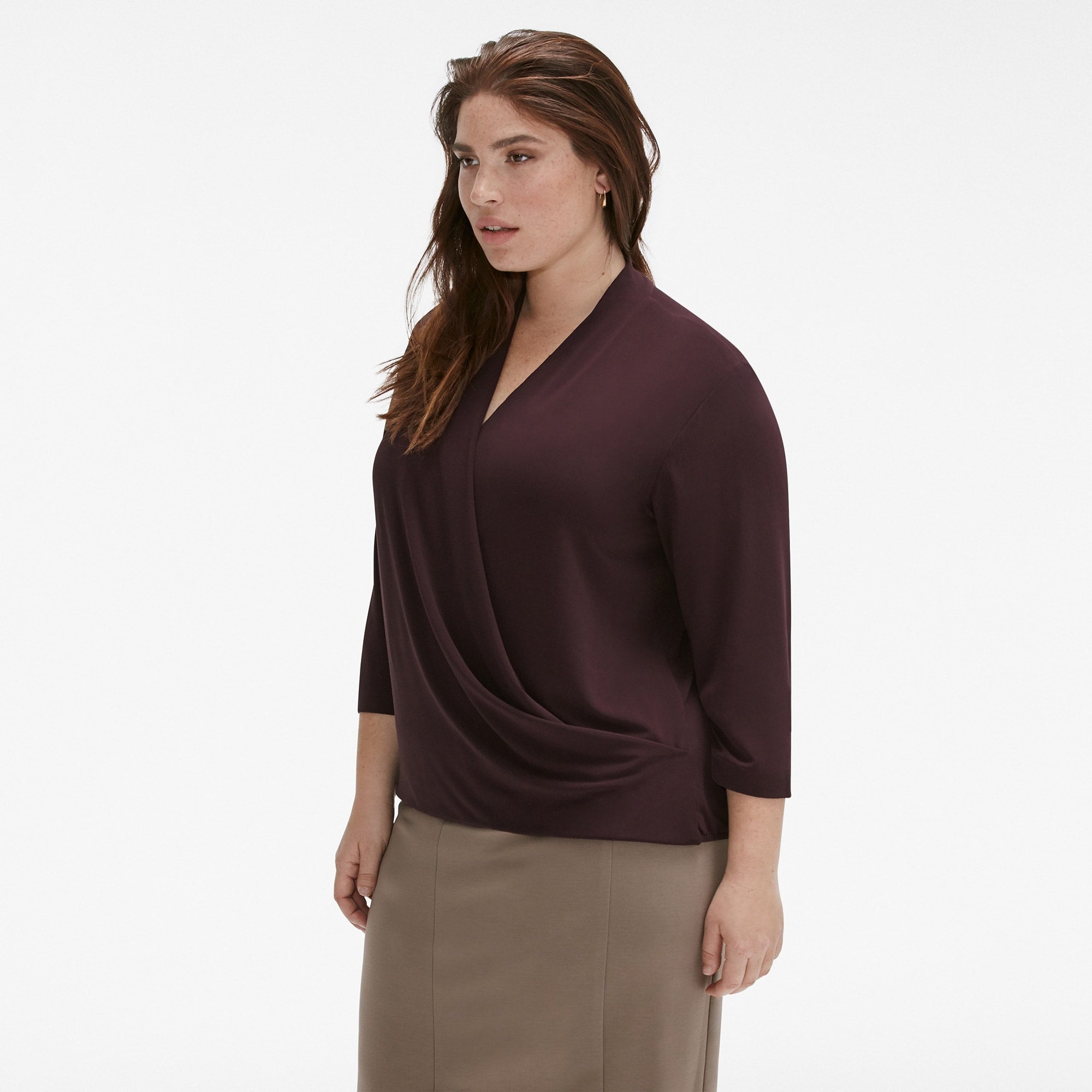Side image of a woman standing wearing the Deneuve Top in blackberry