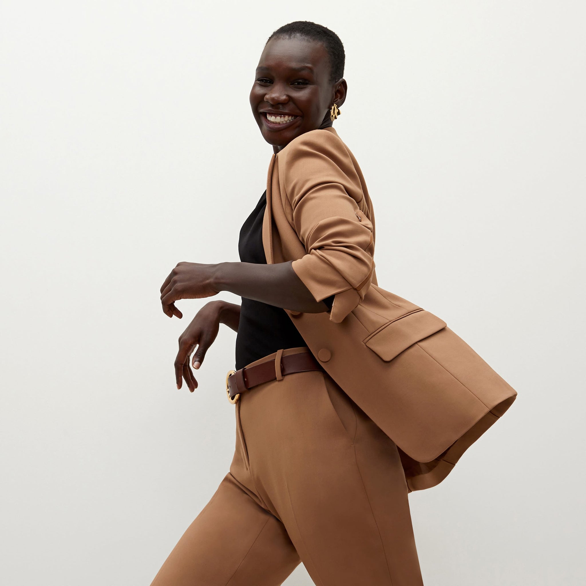 Side image of a woman standing wearing the bennett blazer wool twill in camel