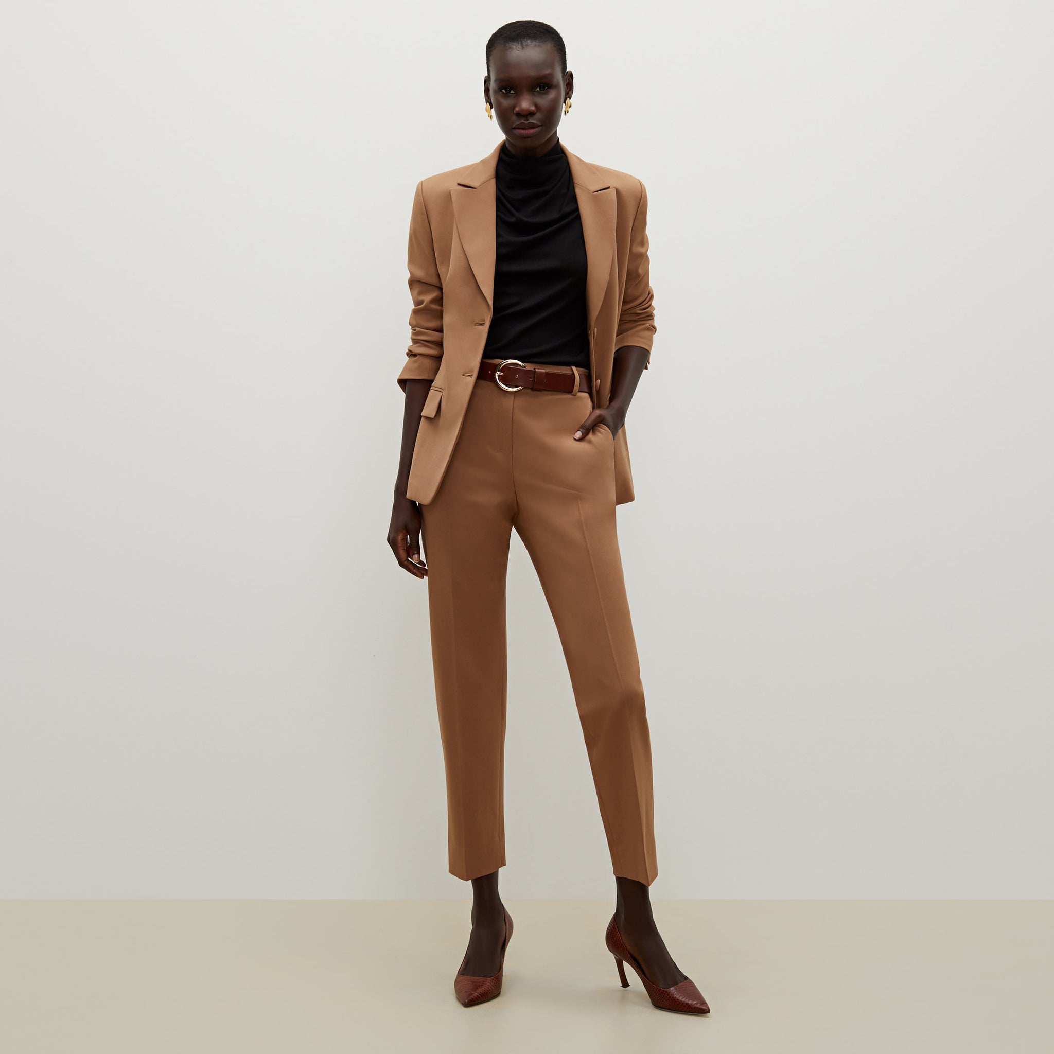 Front image of a woman standing wearing the bennett blazer wool twill in camel
