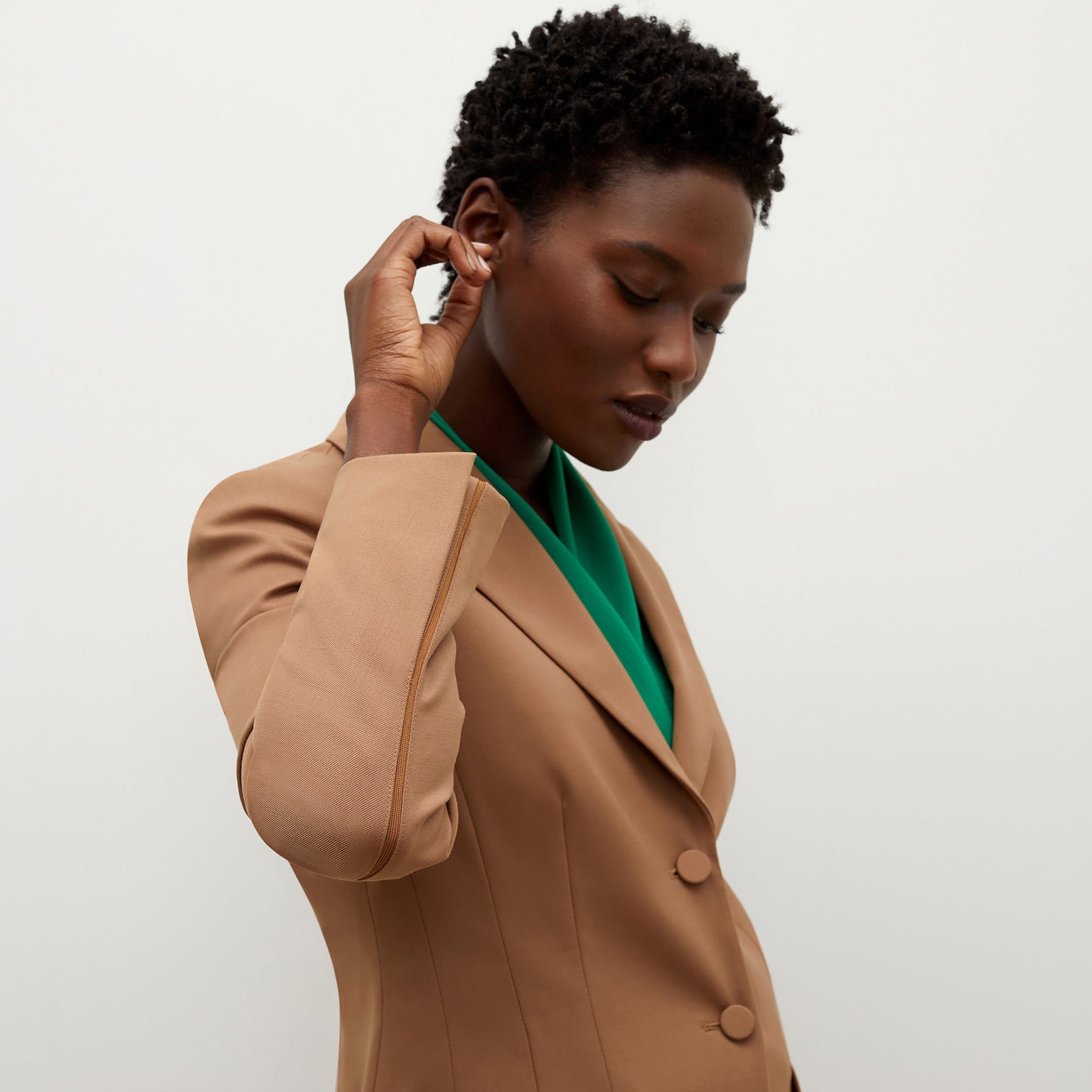 Detail image of a woman standing wearing the bennett blazer wool twill in camel