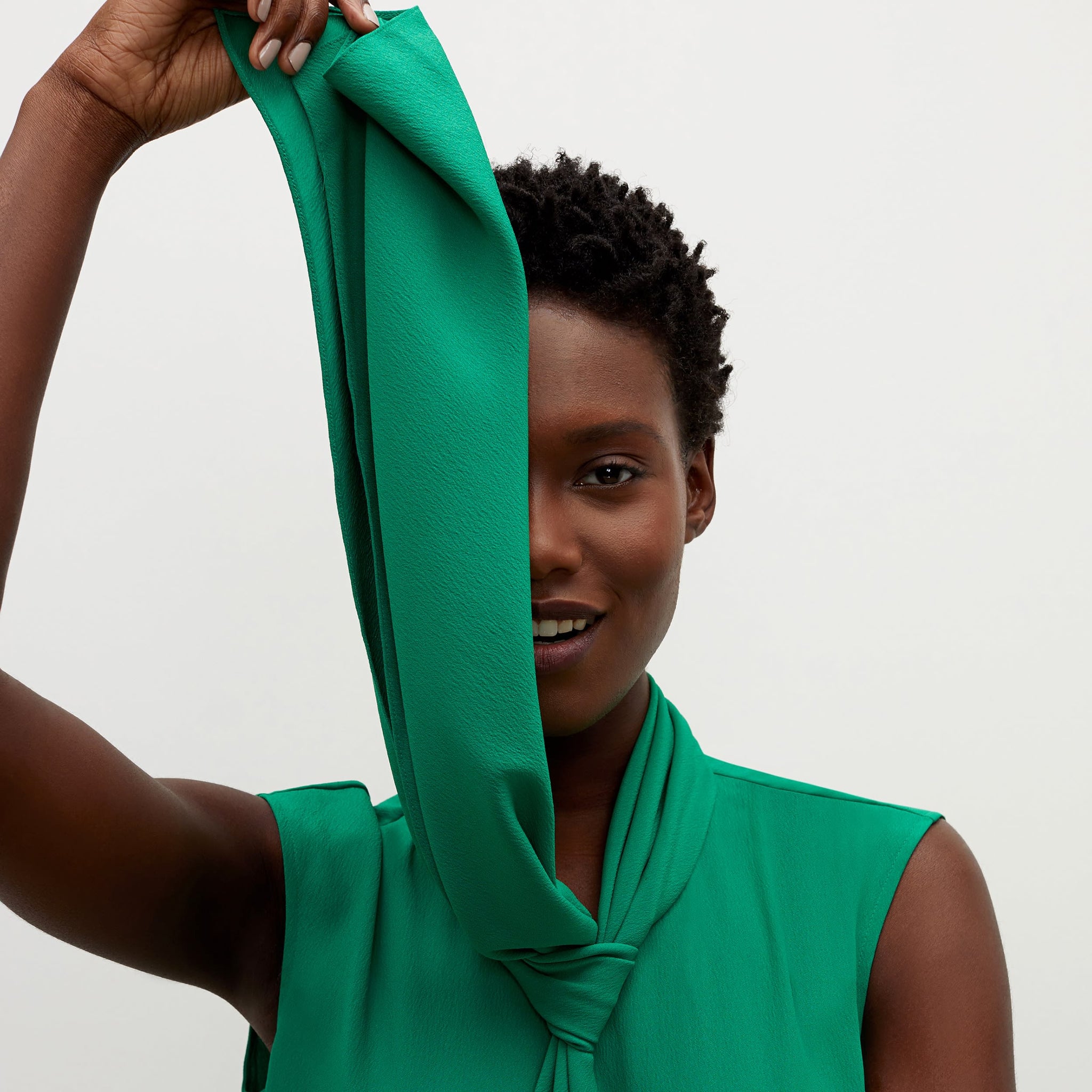 Detail image of a woman standing wearing the beverly top soft wave in emerald
