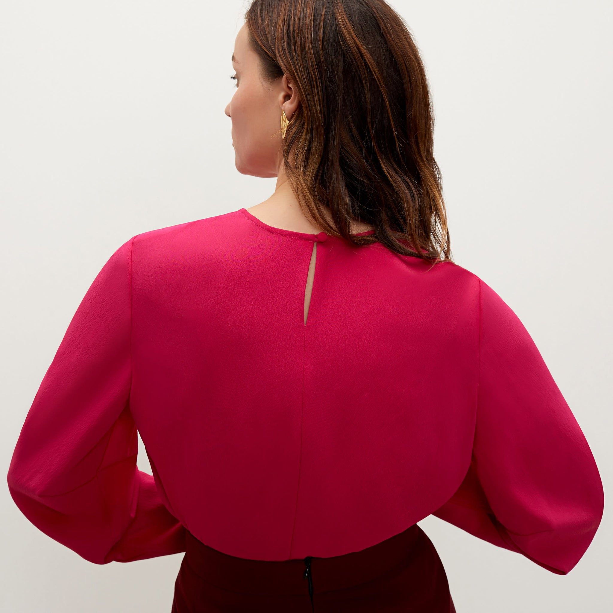 Back image of a woman standing wearing the carrie top soft wave in primrose