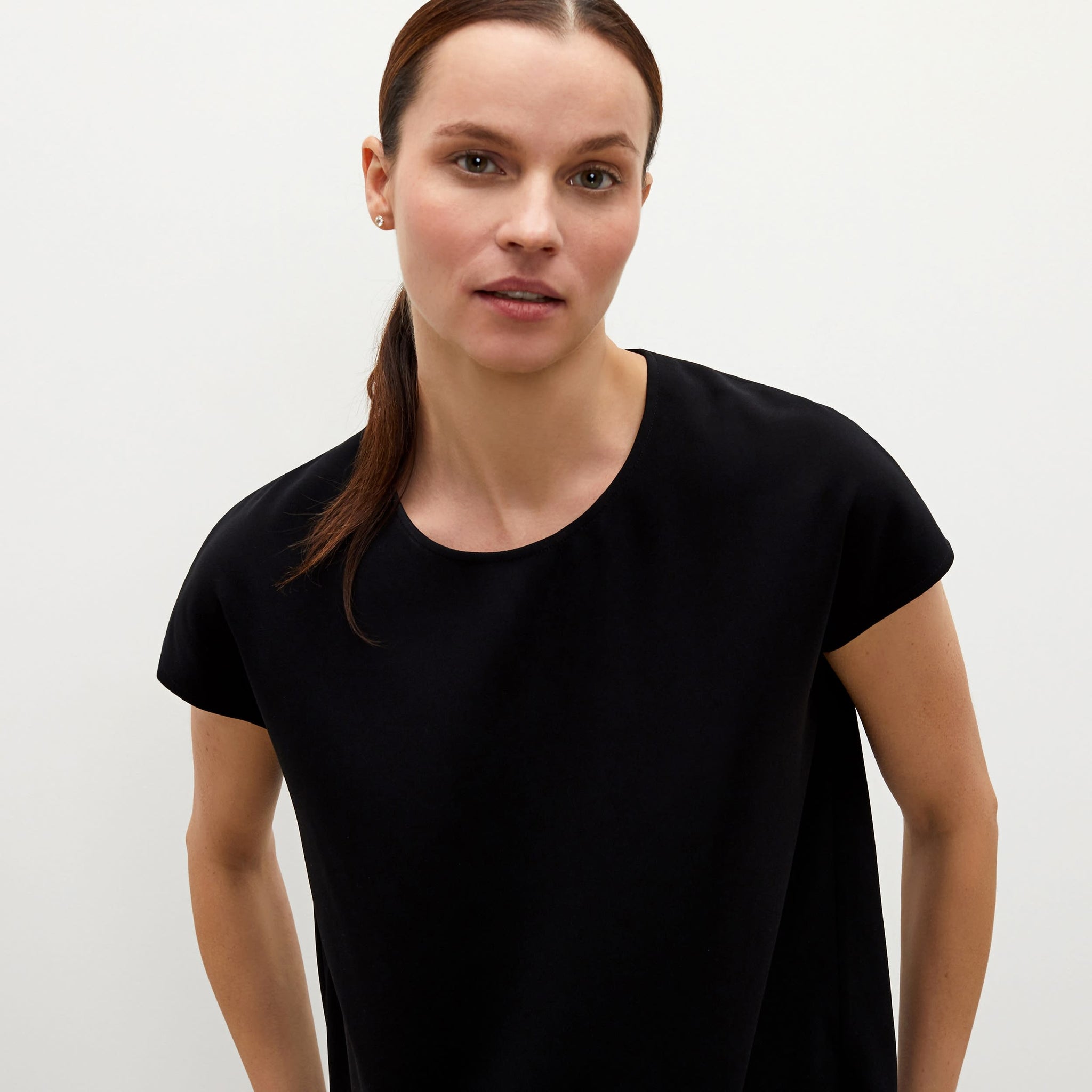 Detail image of a woman standing wearing the Didion top in black
