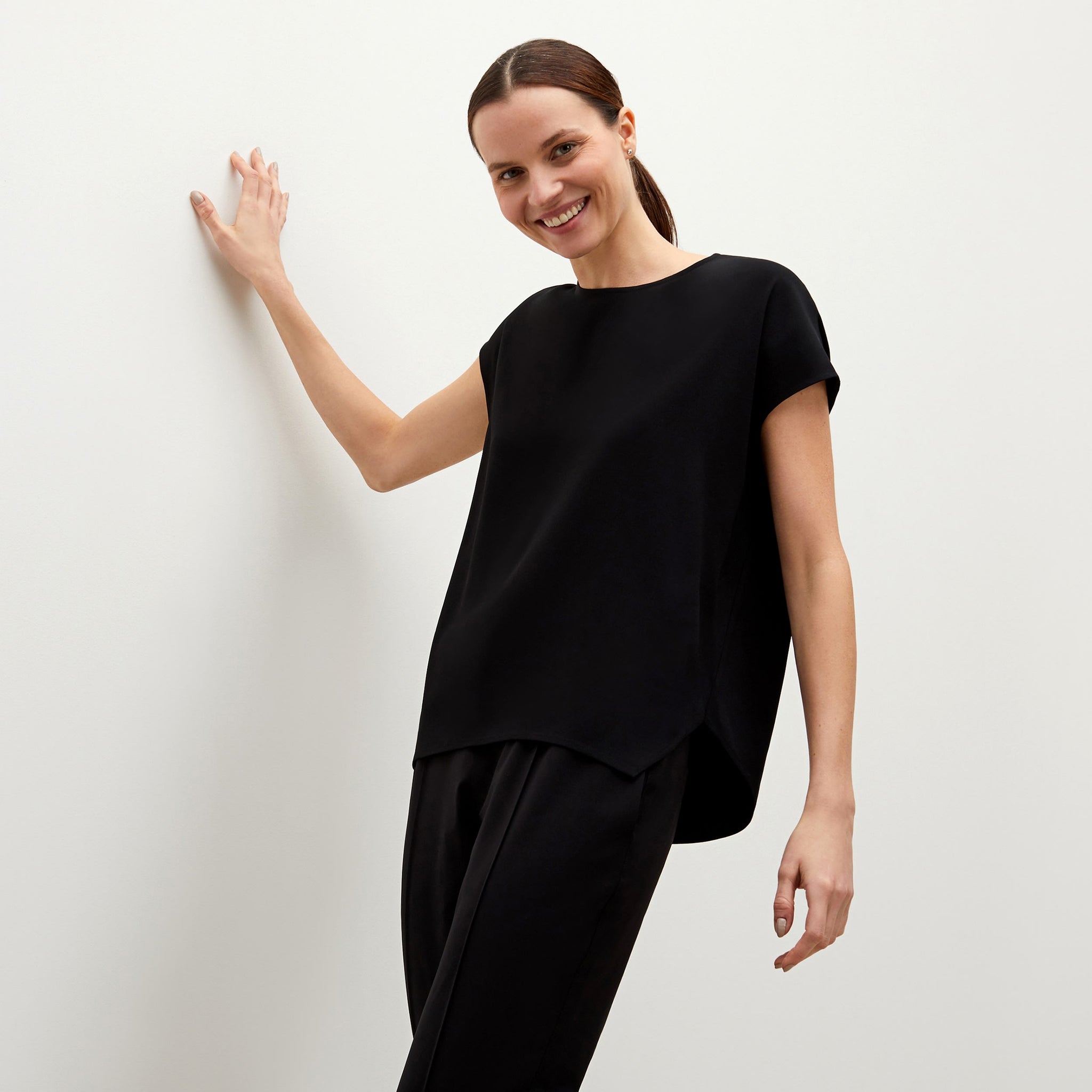 Front image of a woman standing wearing the Didion top in black 