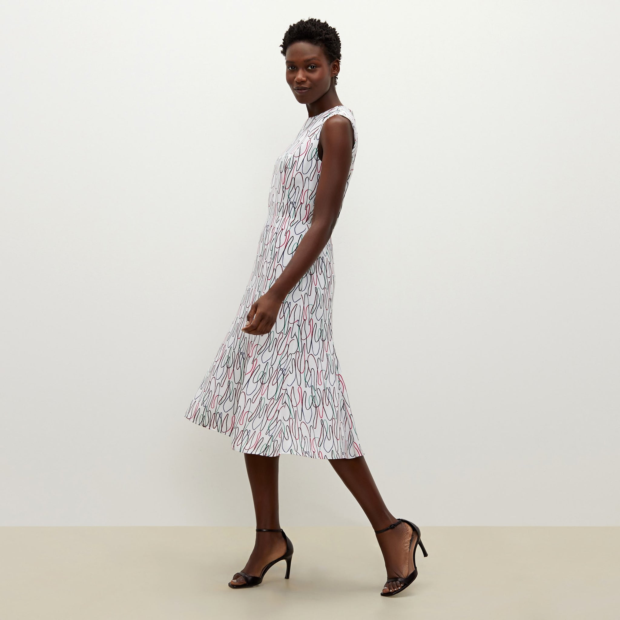 Side image of a woman standing wearing the Jane dress in multicolor