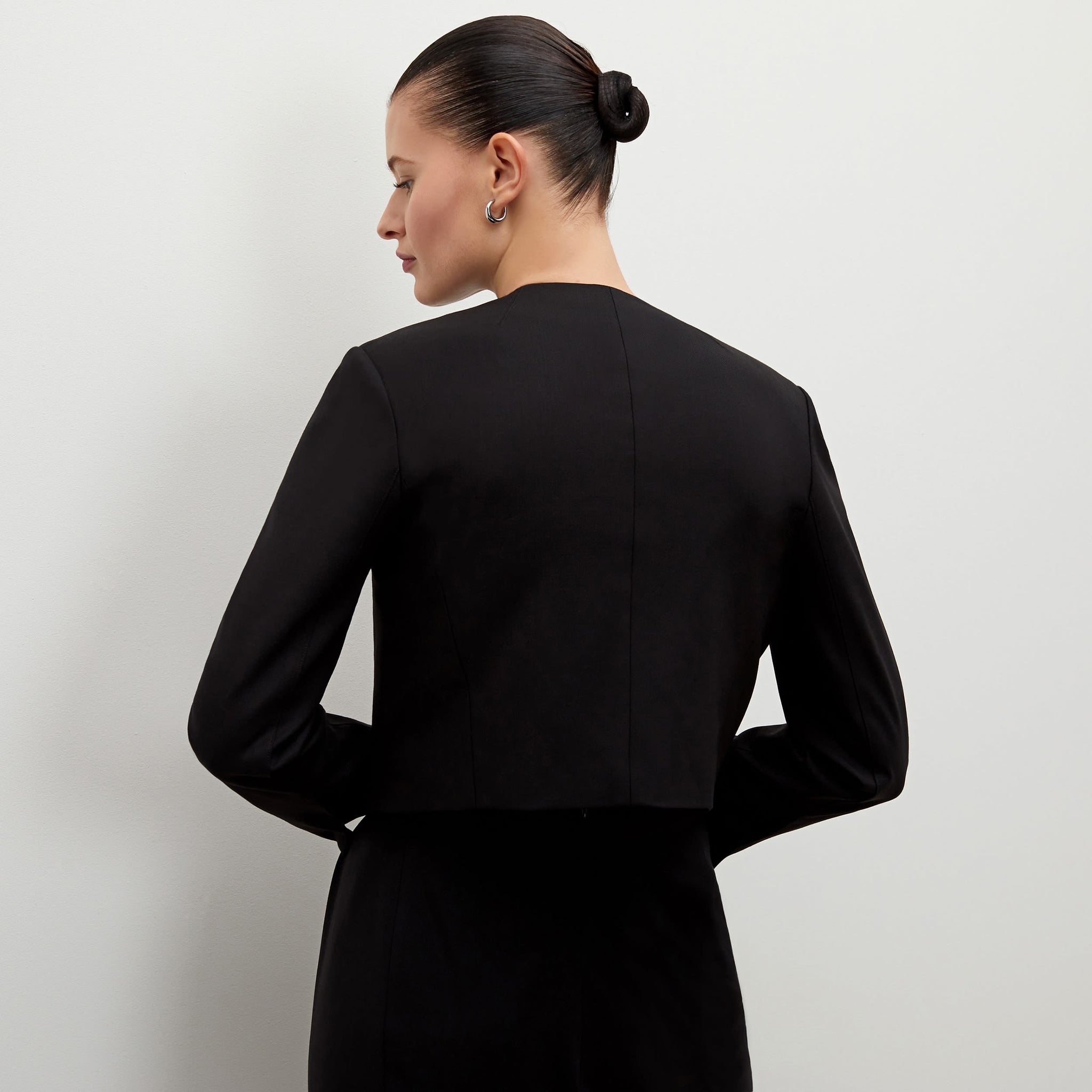 Back image of a woman standing wearing the Neale jacket in black