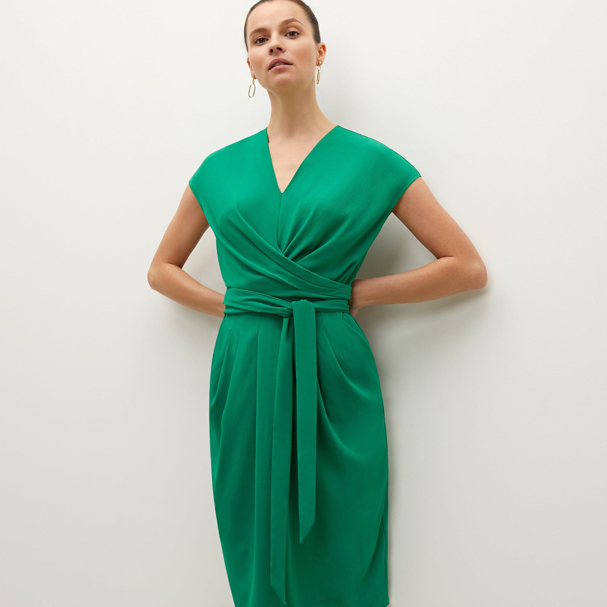 Detail image of a woman standing wearing the Noel dress in emerald