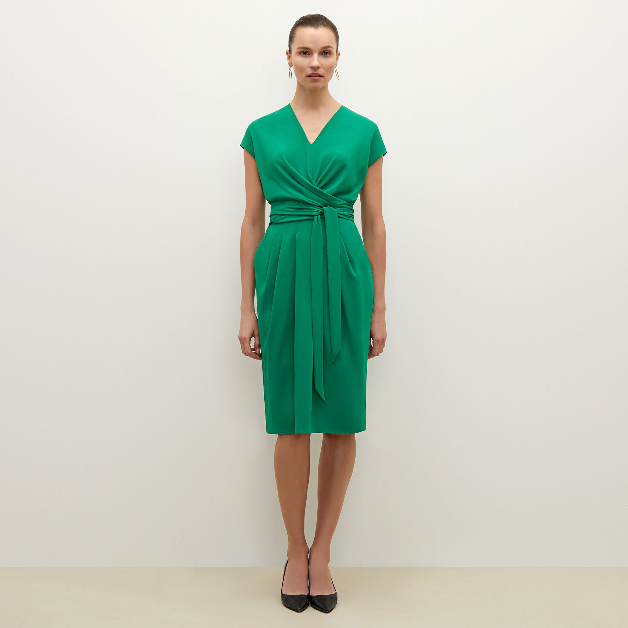 Front image of a woman standing wearing the Noel dress in emerald 