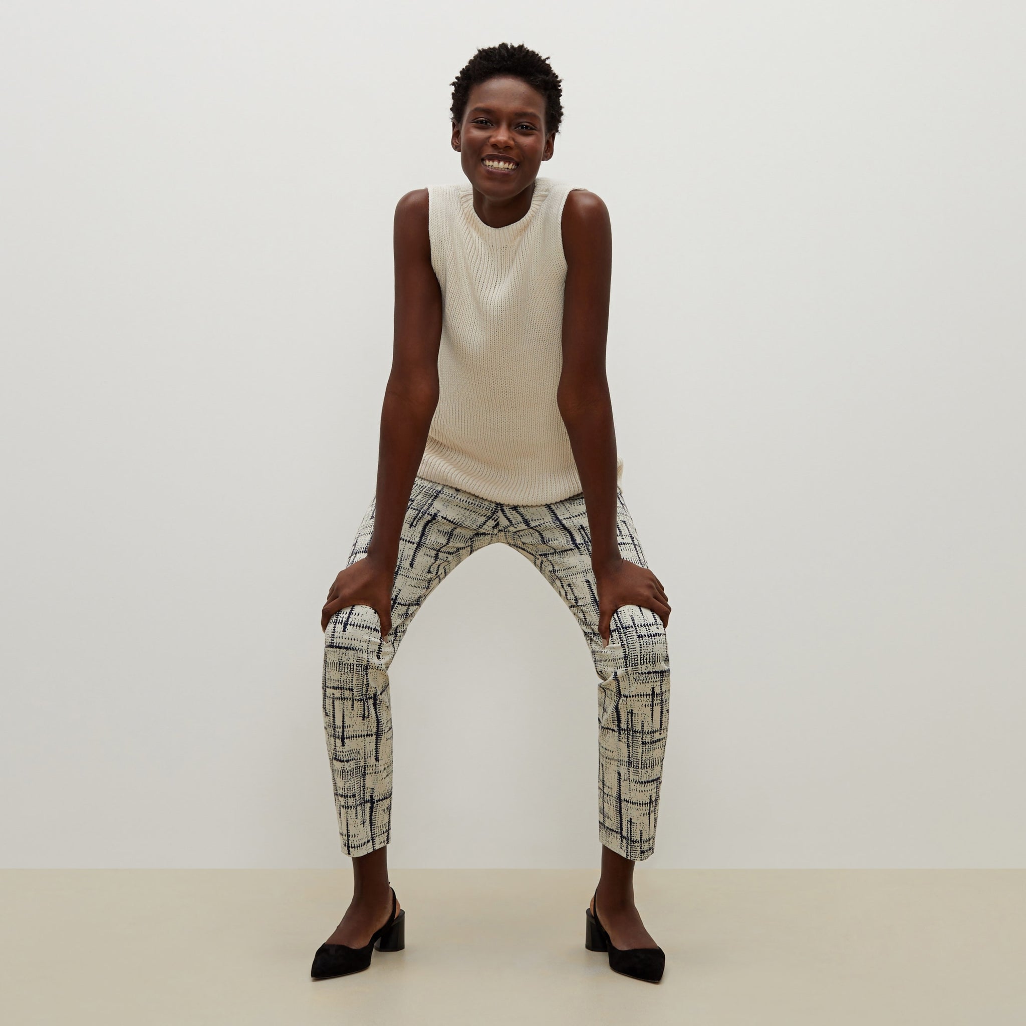 Front image of a woman standing wearing the Spardel top in ivory