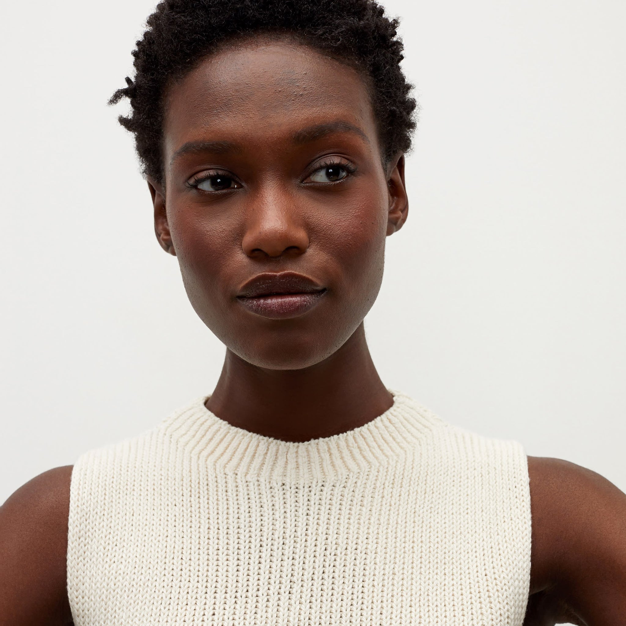 Detail image of a woman standing wearing the Spardel top in ivory