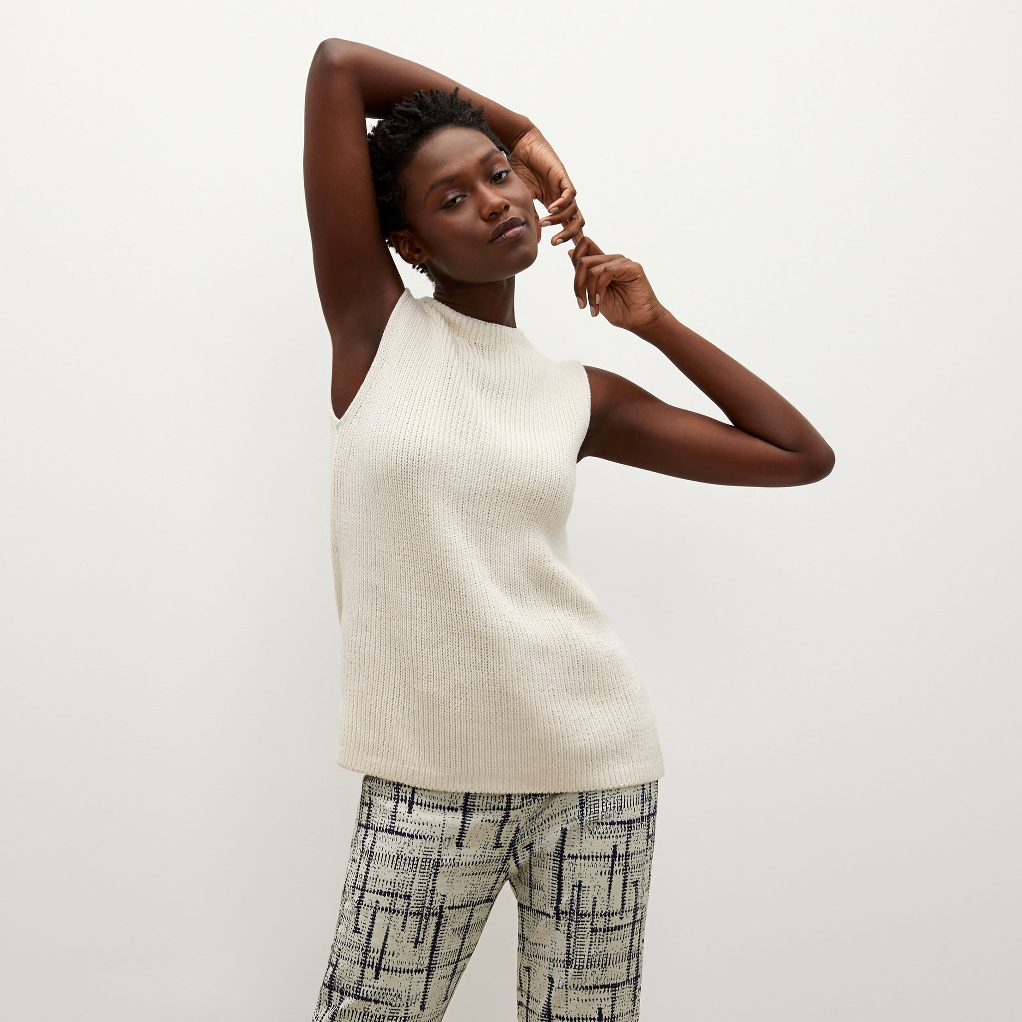 Front image of a woman standing wearing the Spardel top in ivory 