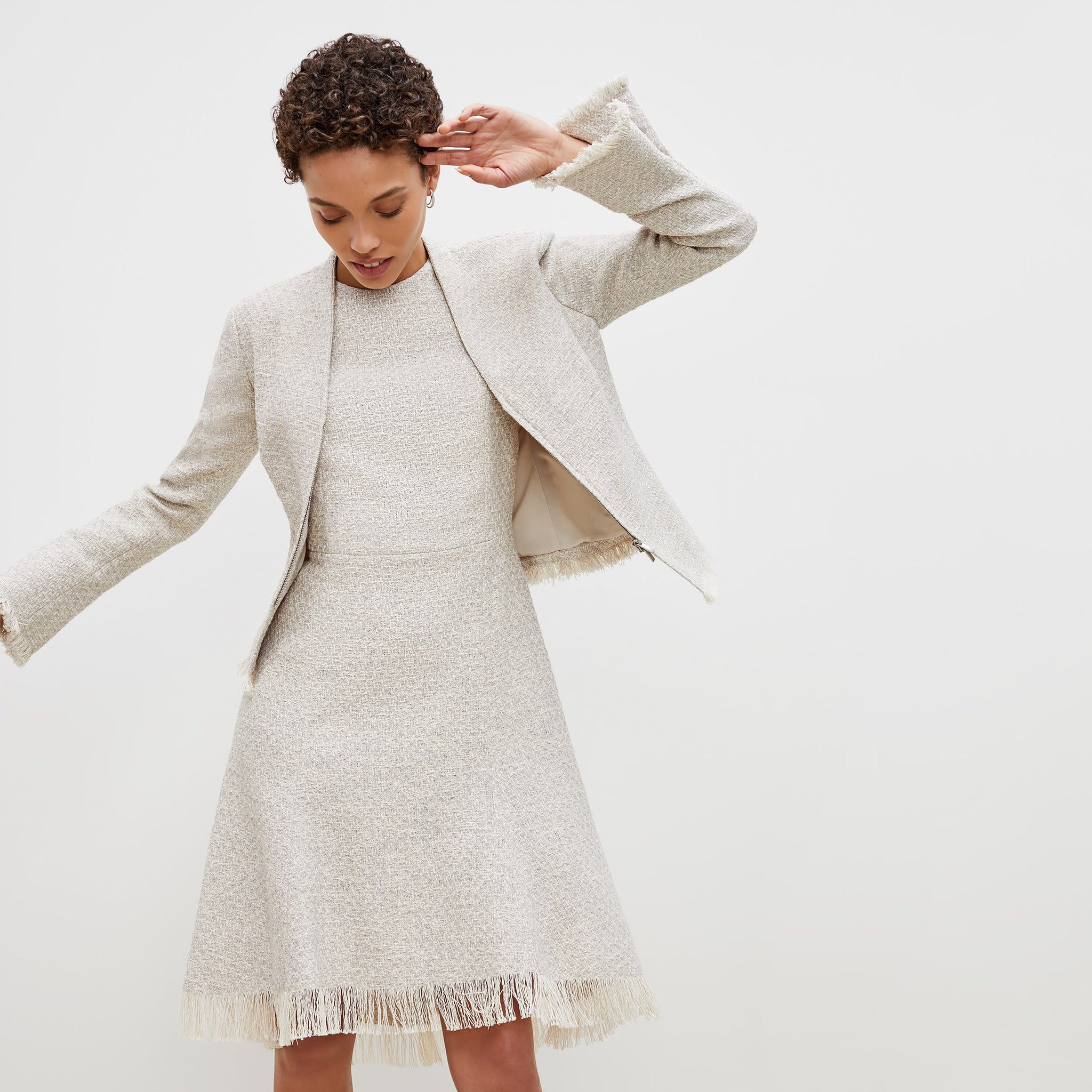 Front image of a woman standing wearing the lindsay dress cotton boucle in sea salt / ivory
