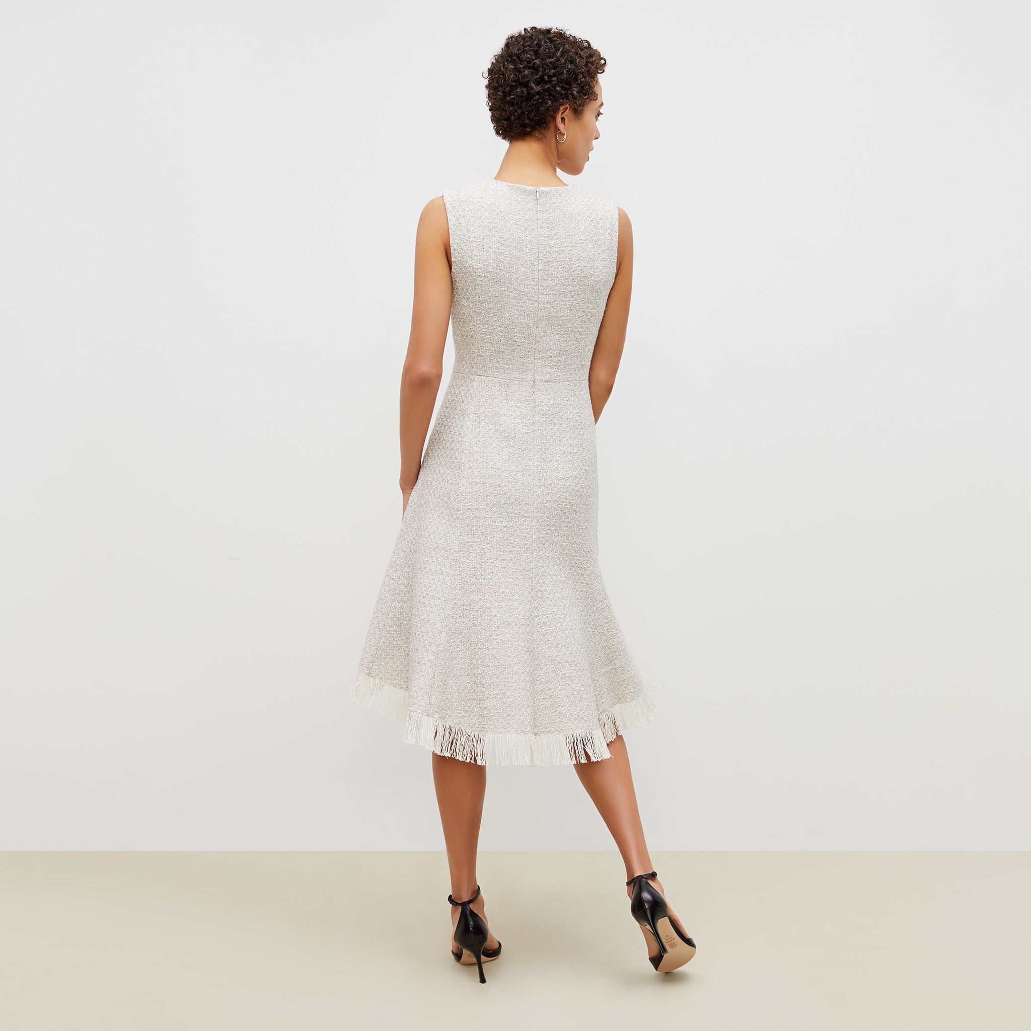 Back image of a woman standing wearing the lindsay dress cotton boucle in sea salt / ivory