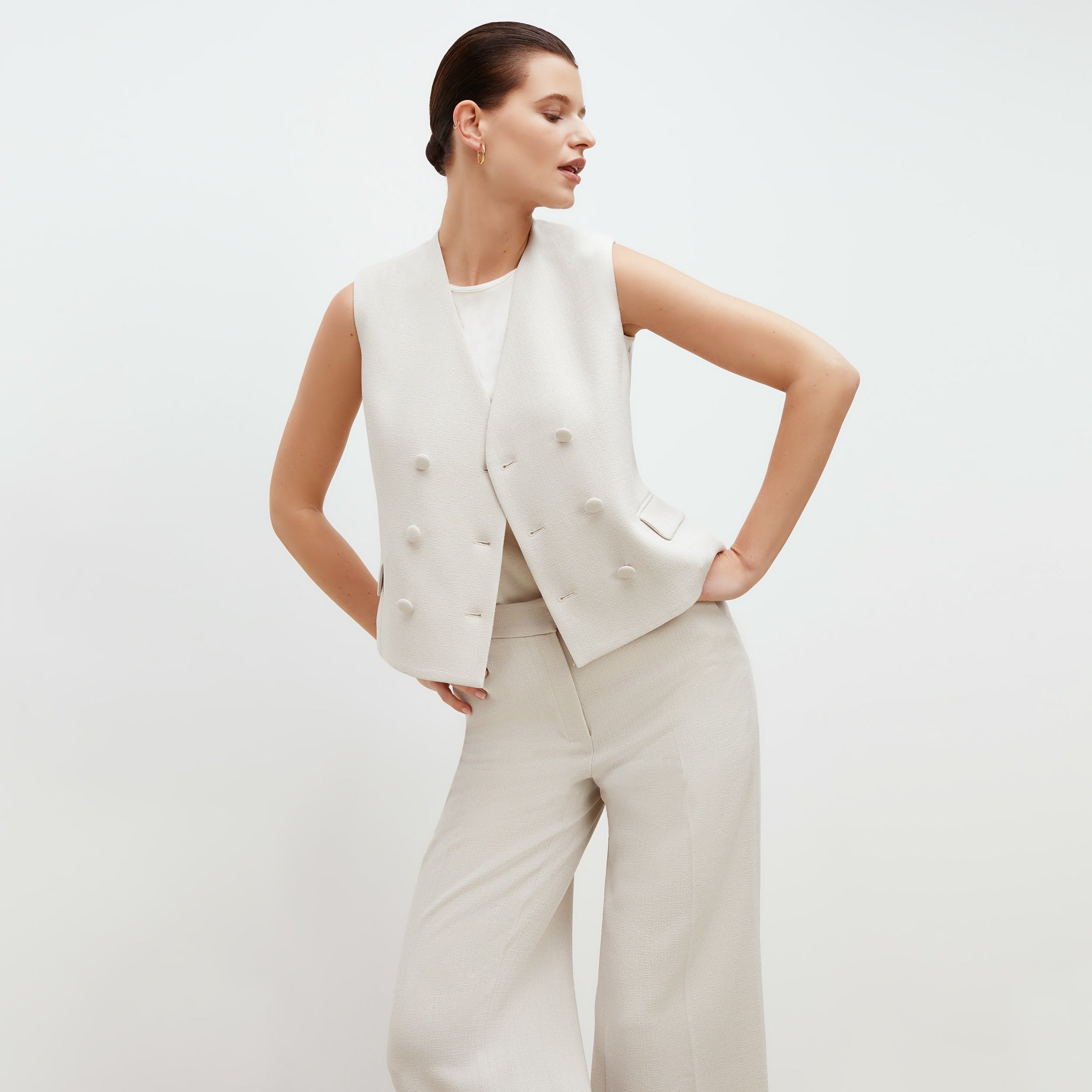 Front image of a woman standing wearing the willow vest in textured suiting in magnolia