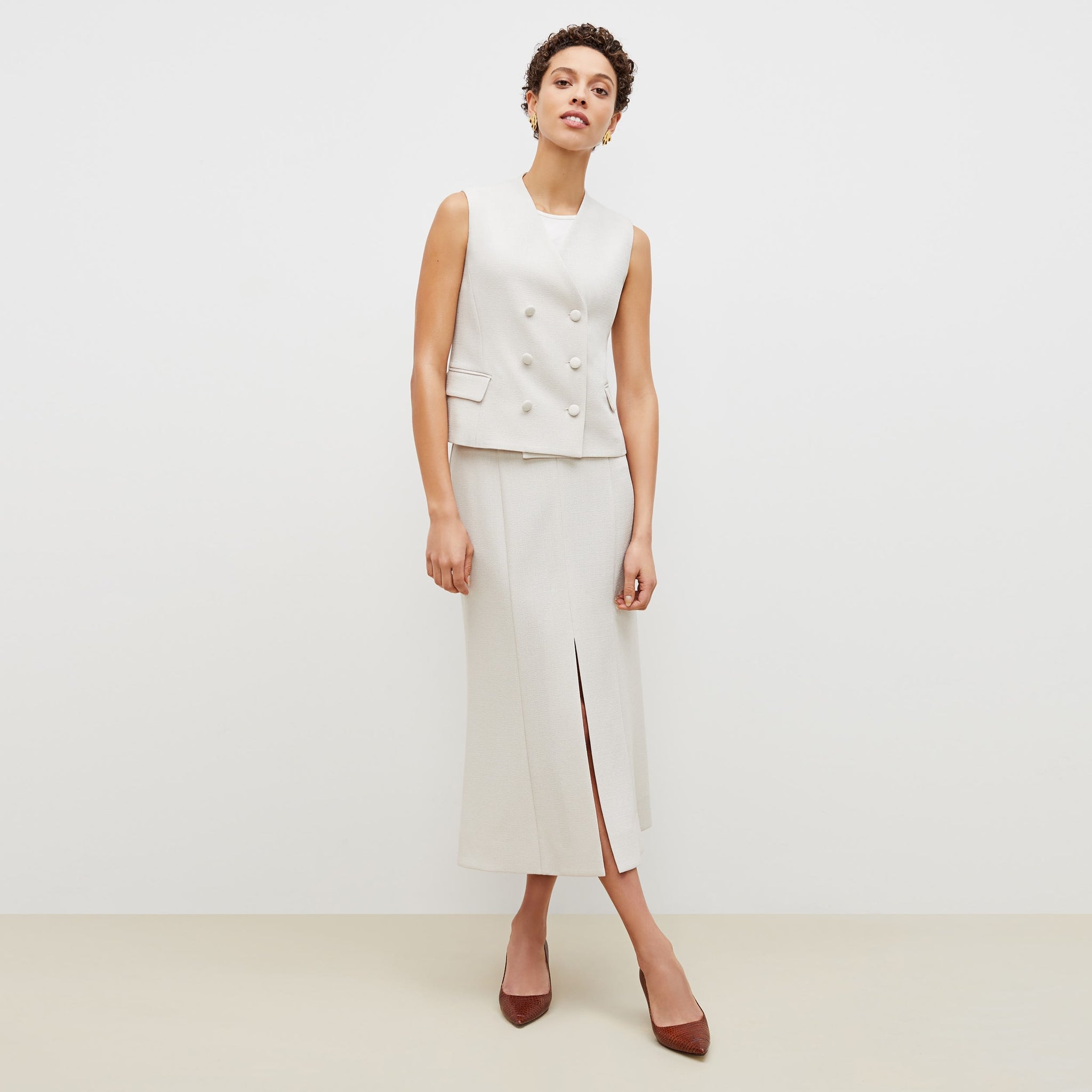 Front image of a woman standing wearing the eva skirt in textured suiting in magnolia