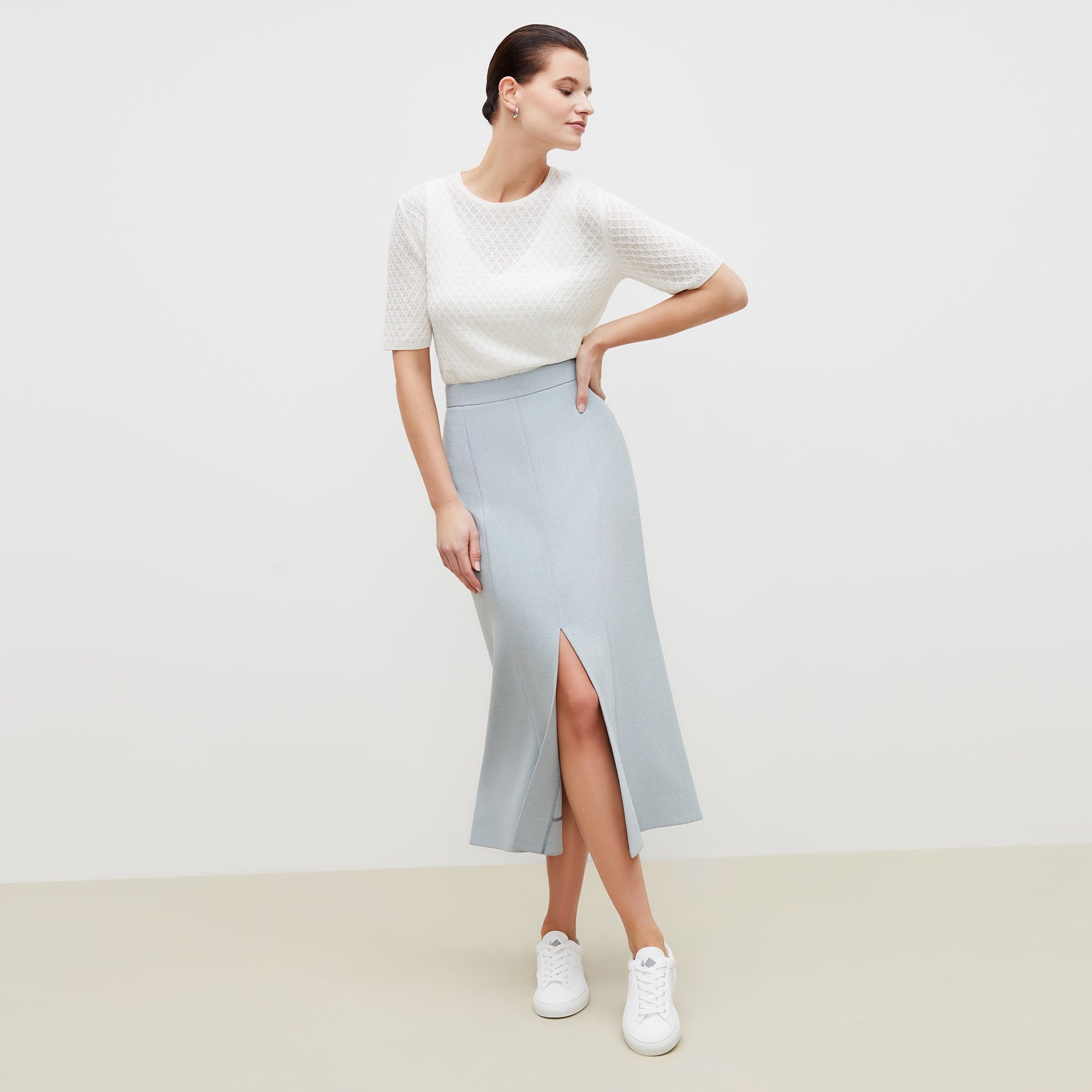Front image of a woman standing wearing the eva skirt in textured suiting in powder blue