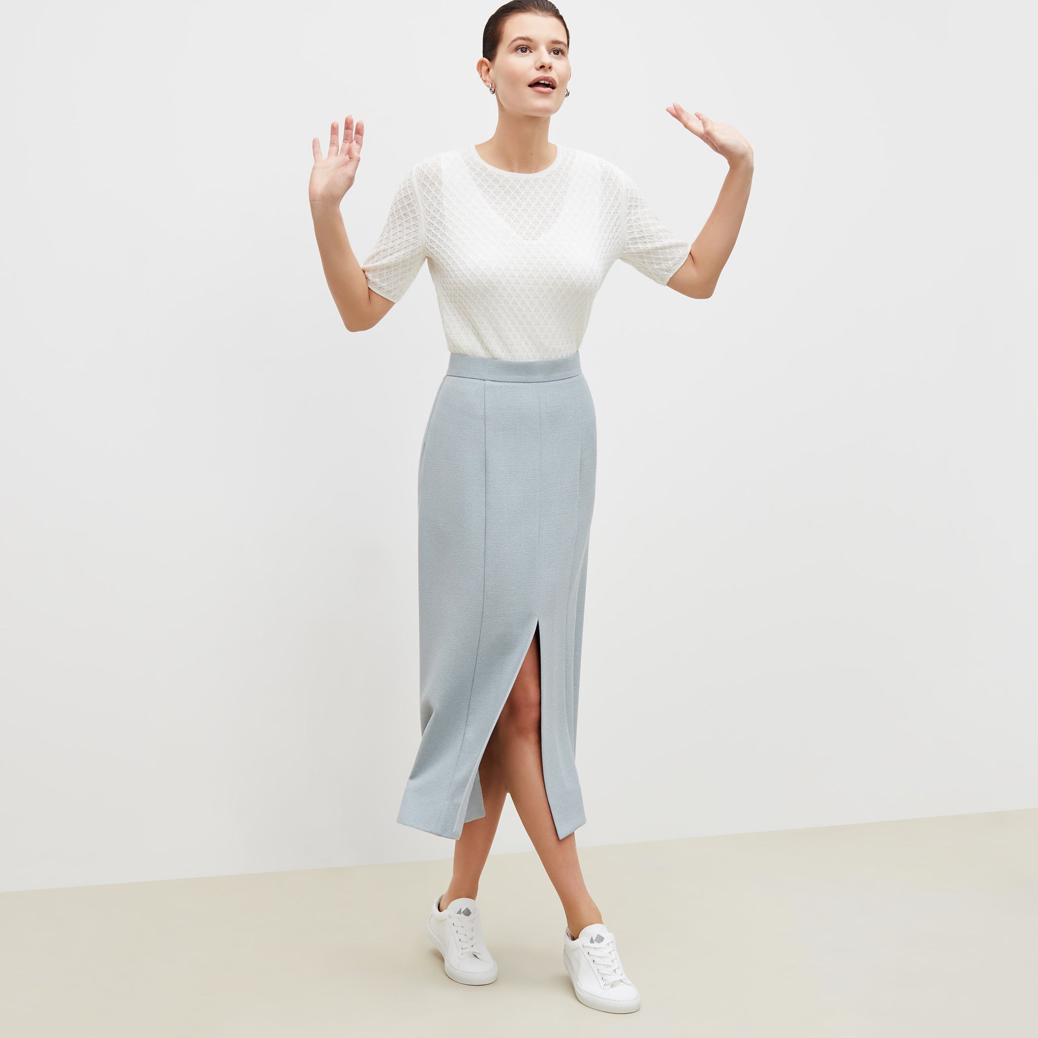 Front image of a woman standing wearing the eva skirt in textured suiting in powder blue