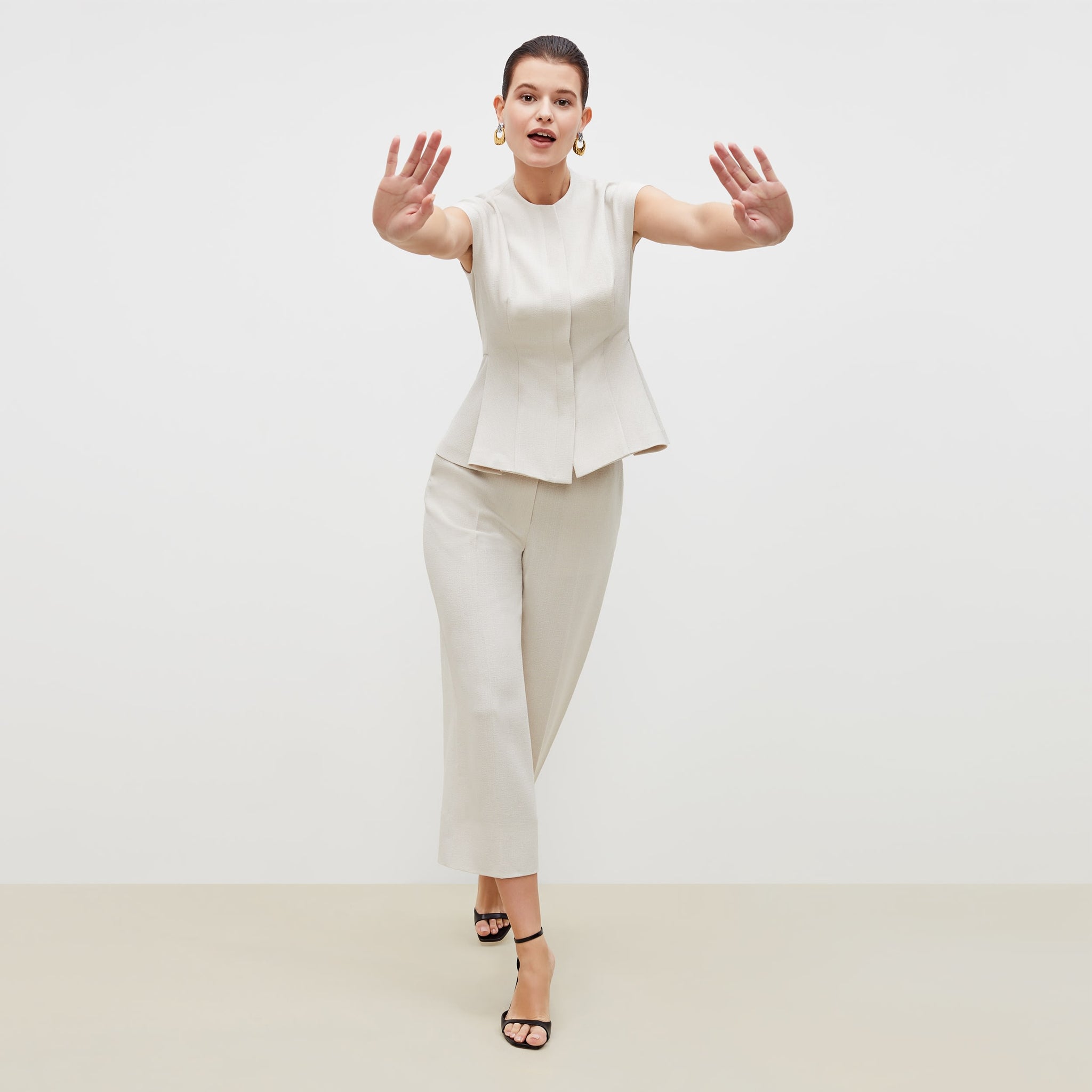 Front image of a woman standing wearing the anderson pant in textured suiting in magnolia