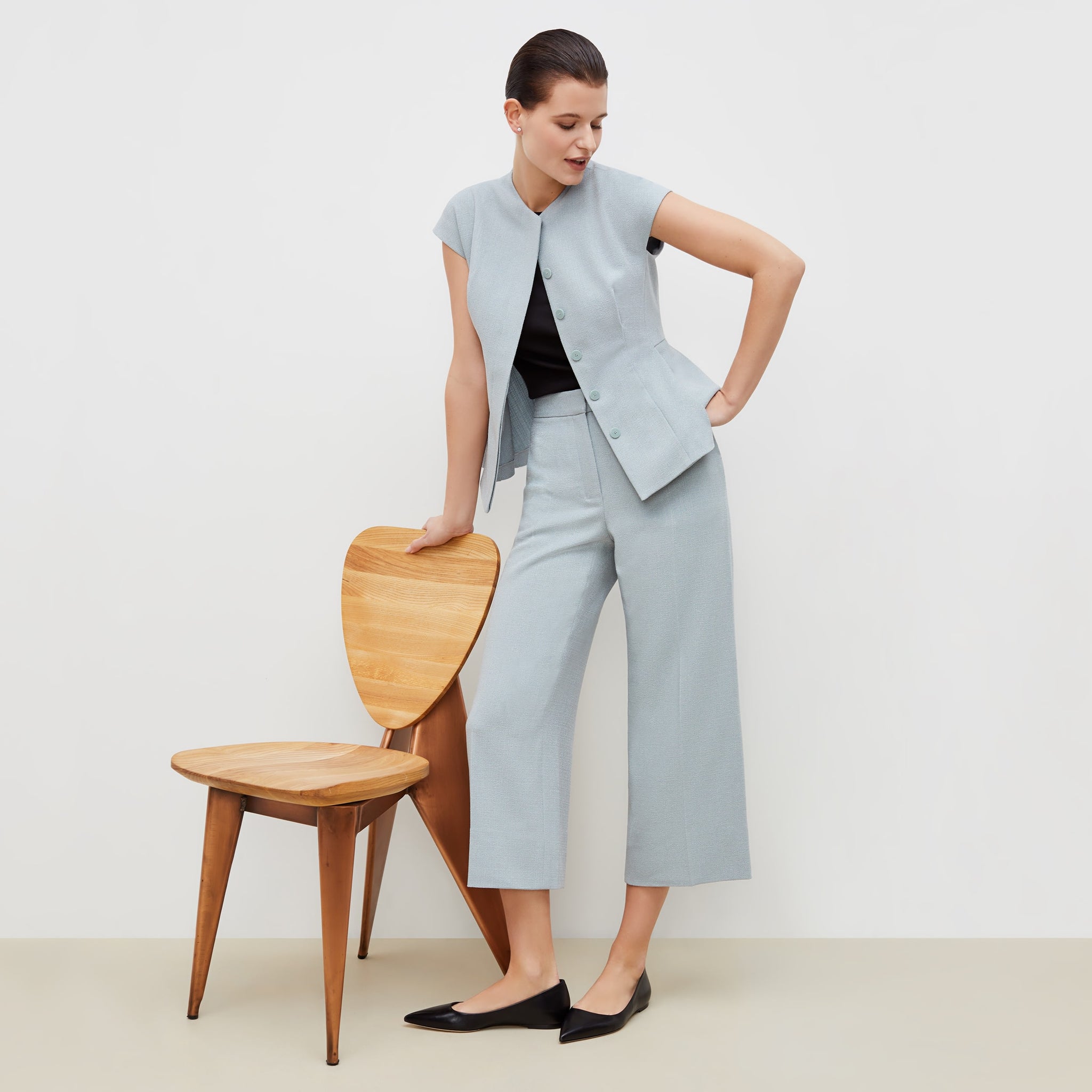 Front image of a woman standing wearing the anderson pant in textured suiting in powder blue