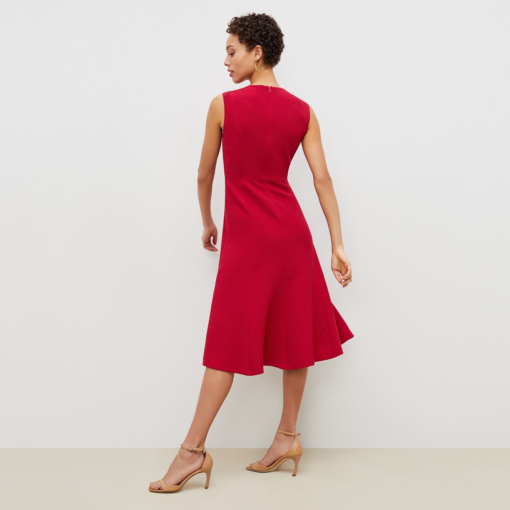 Back image of a woman standing wearing the jane dress in staccato in hibiscus