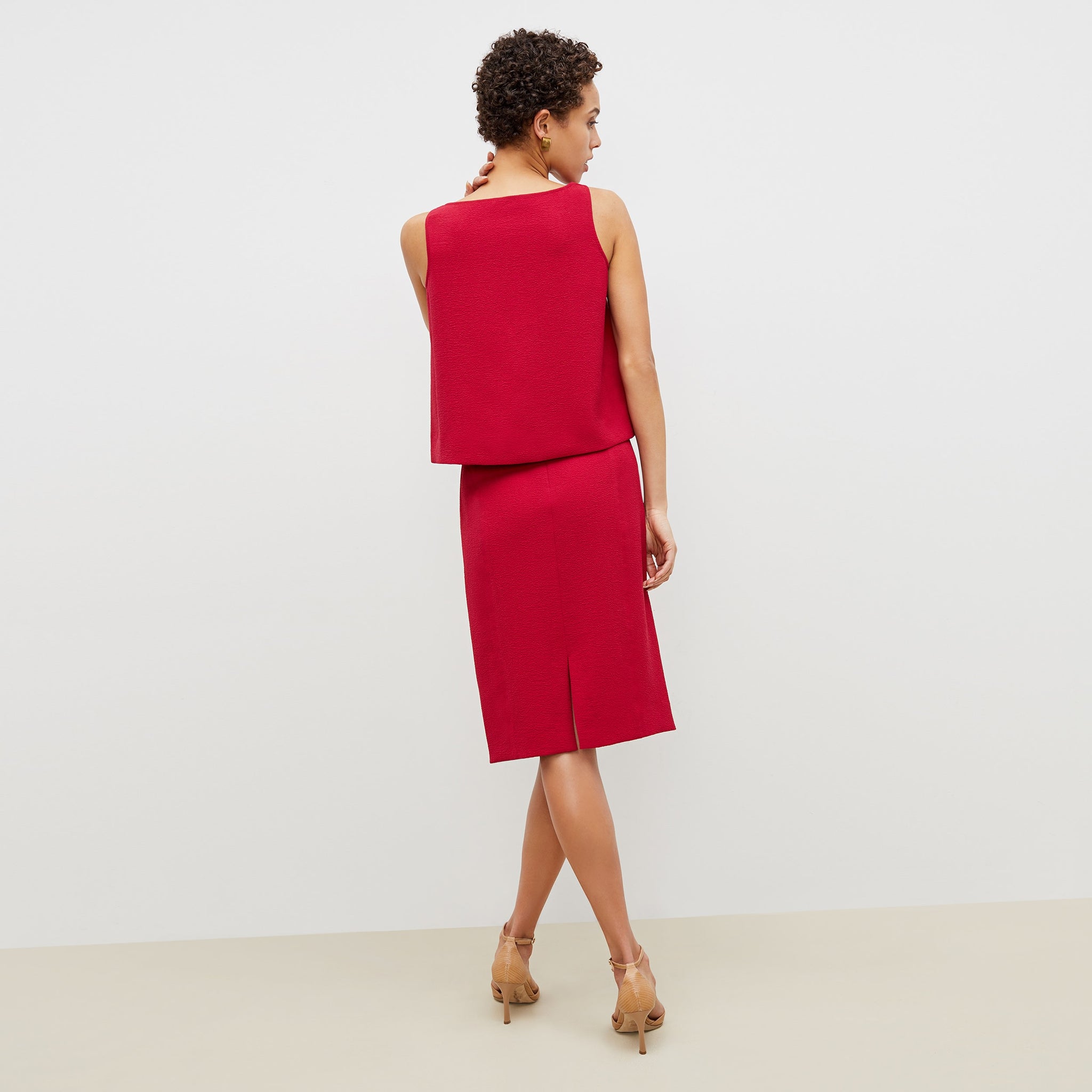 Back image of a woman standing wearing the flaka top in staccato in hibiscus