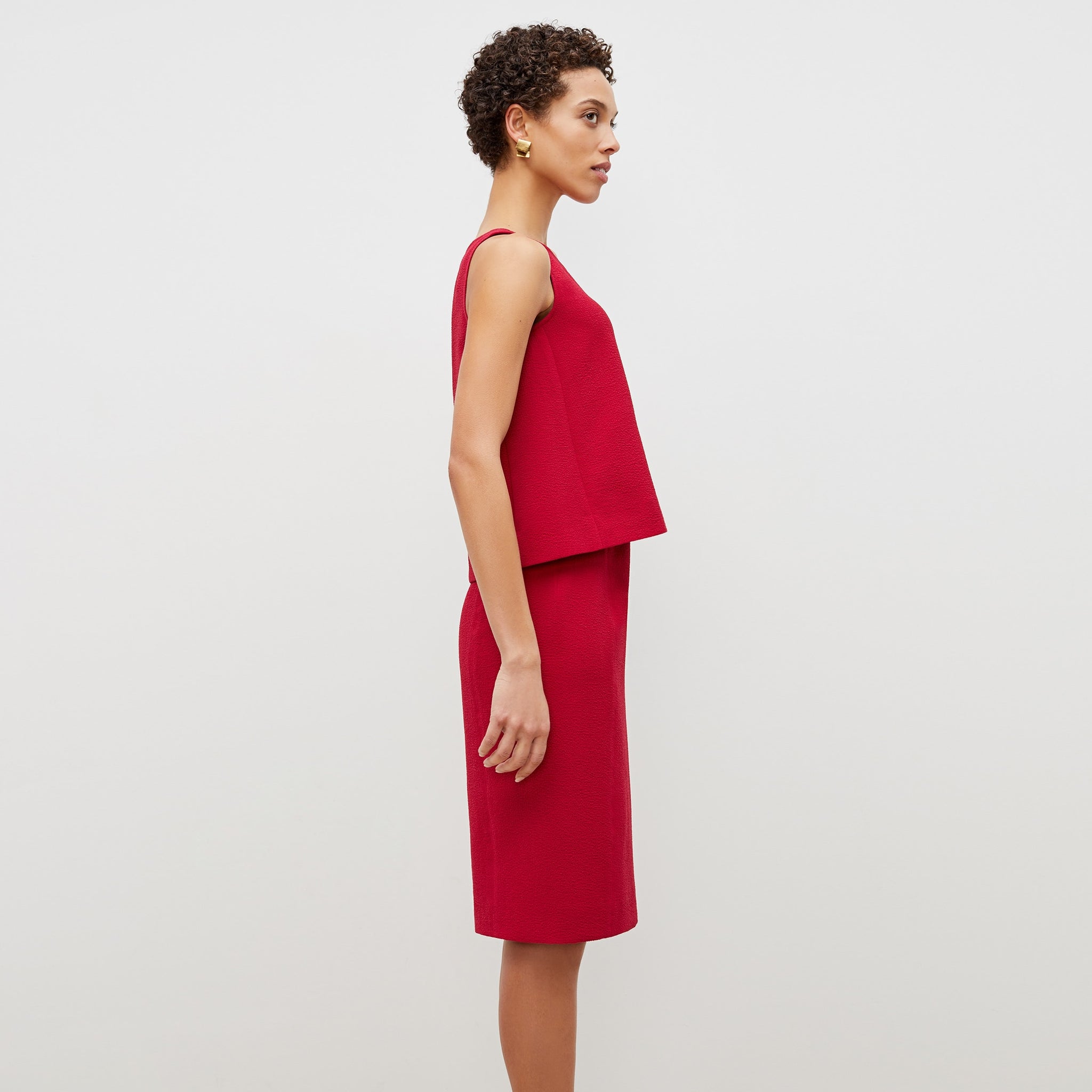 Side image of a woman standing wearing the flaka top in staccato in hibiscus