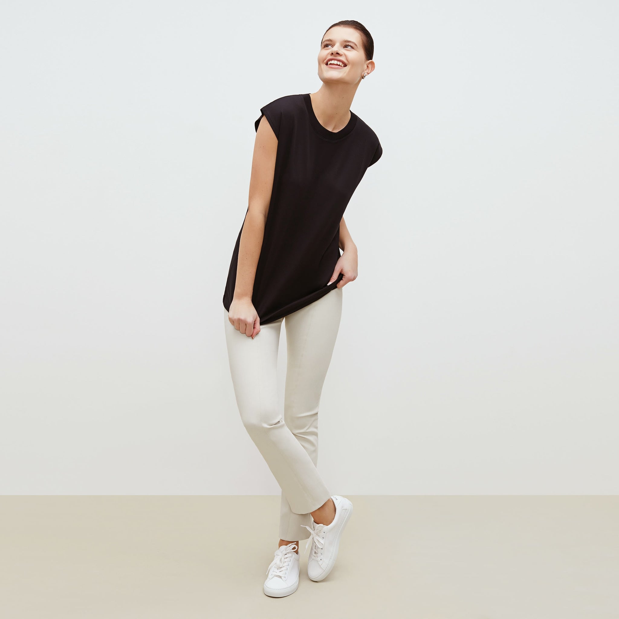 Front image of a woman standing wearing the alina top in compact cotton in black