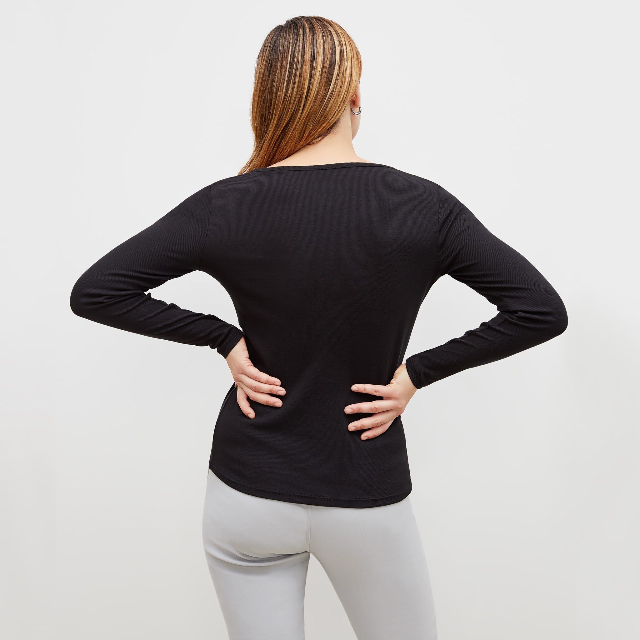 Back image of a woman standing wearing the marcia top in fine ribbed cotton in black