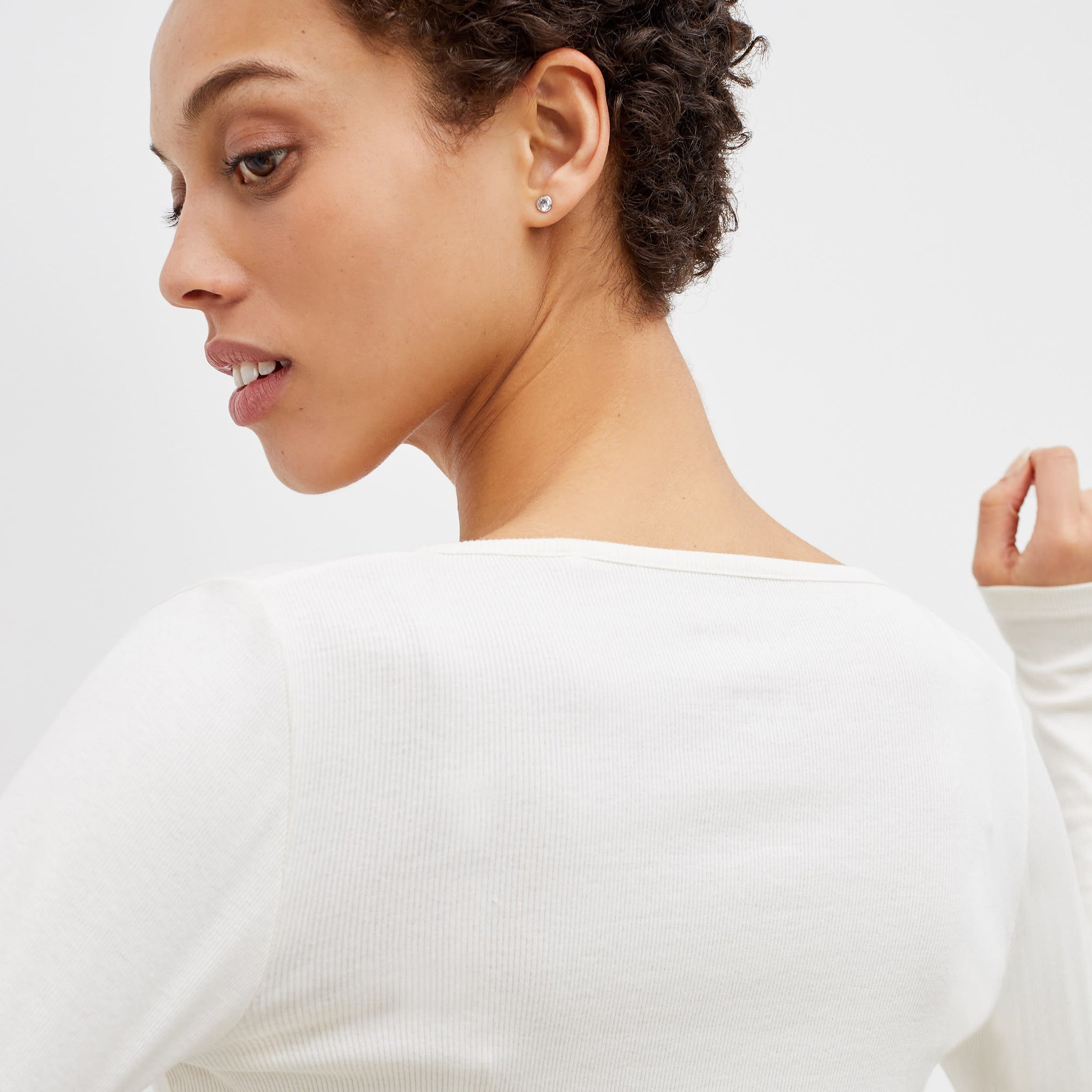 Back image of a woman standing wearing the marcia top in fine ribbed cotton in ivory