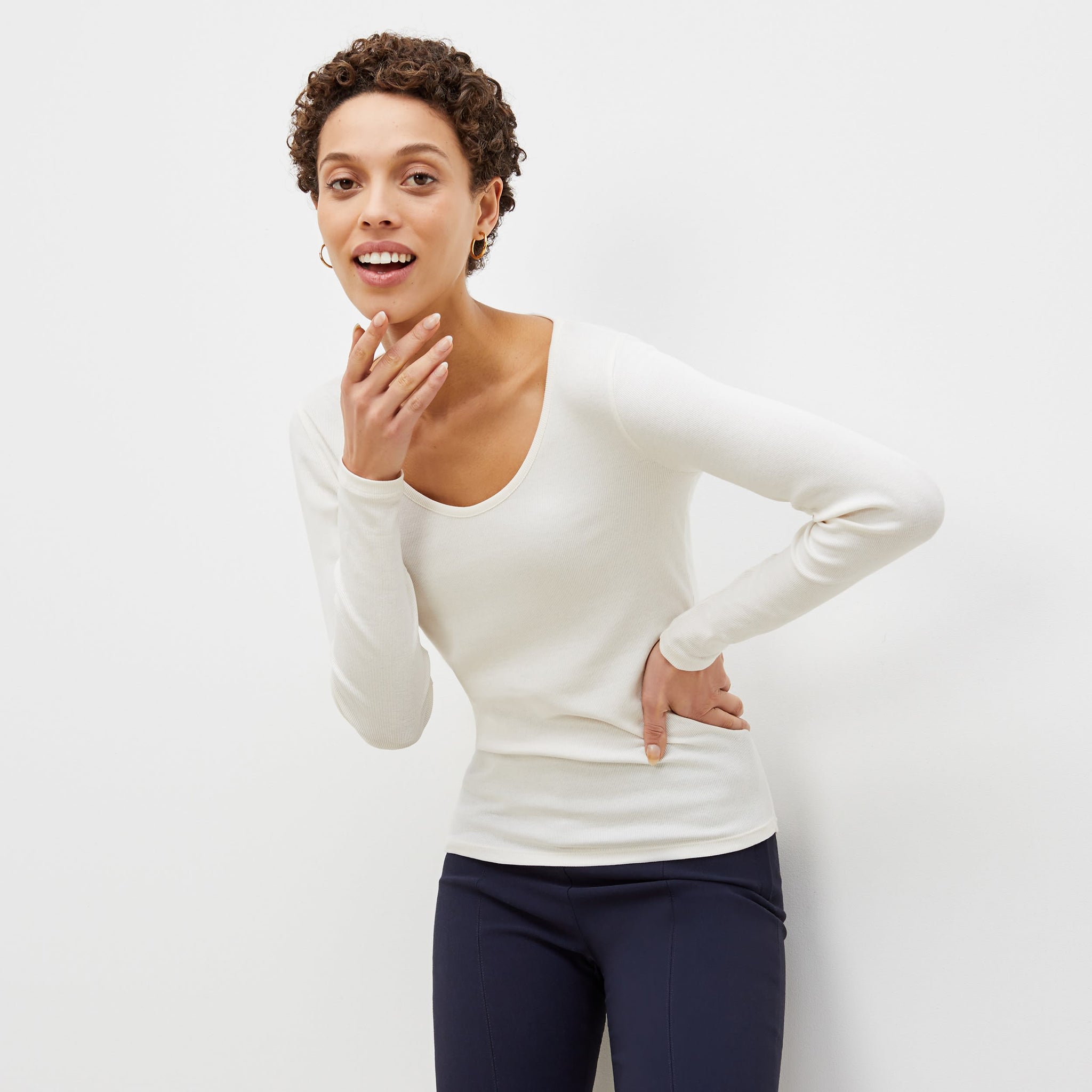 Front image of a woman standing wearing the marcia top in fine ribbed cotton in ivory 