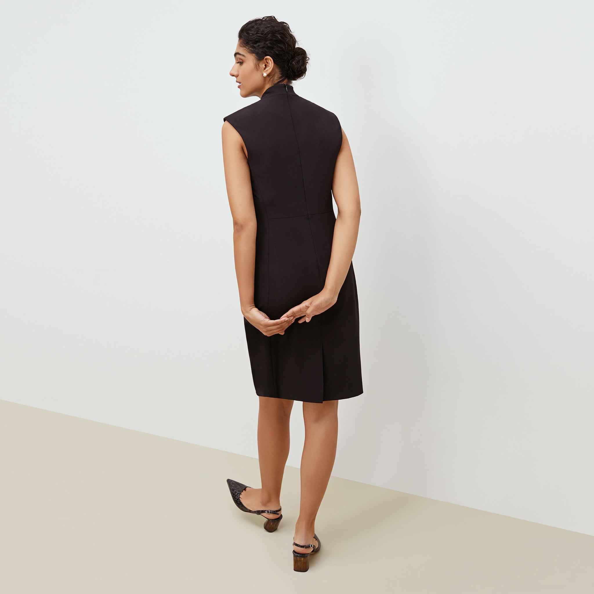 Back image of a woman standing wearing the Aditi dress in black