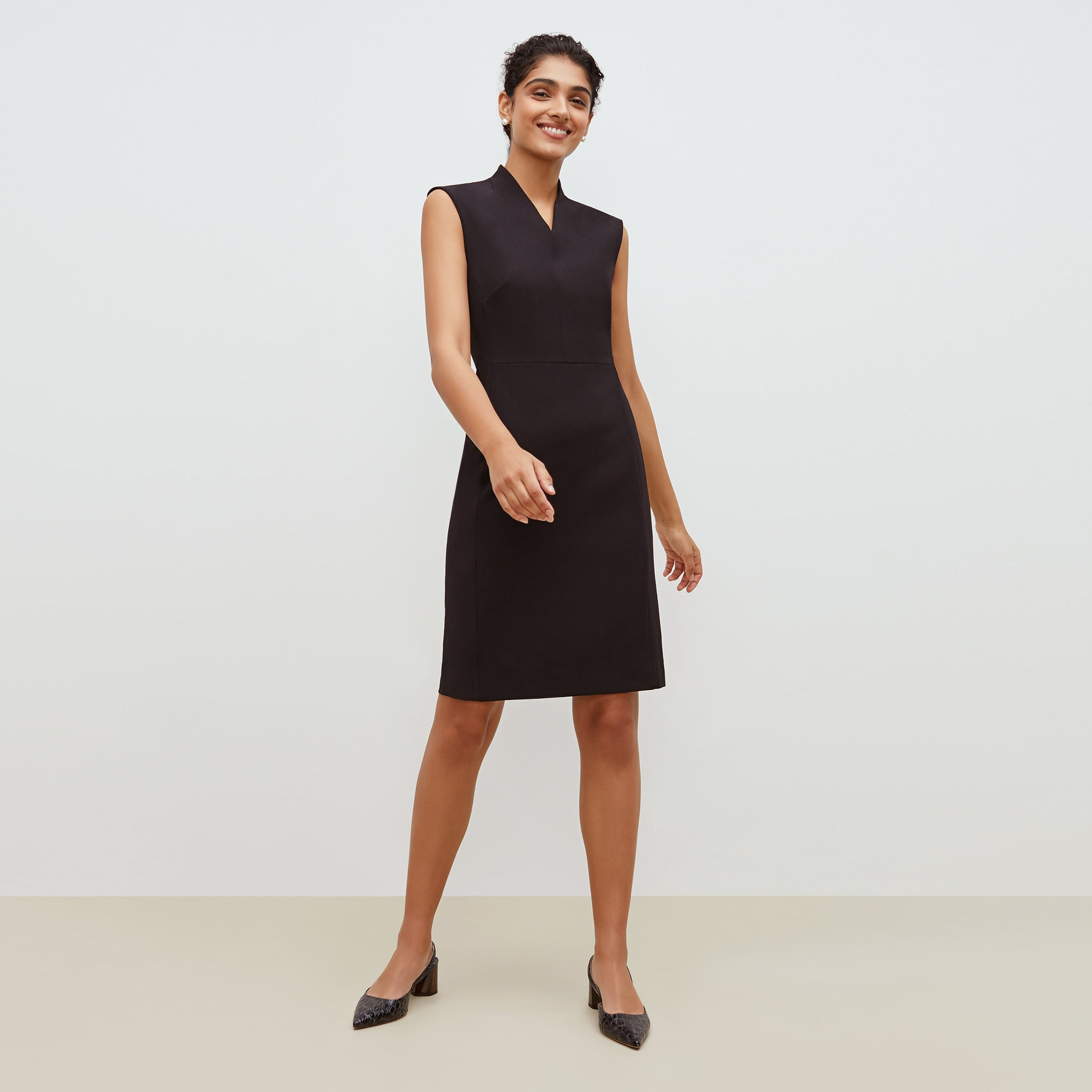 Front image of a woman standing wearing the Aditi dress in black