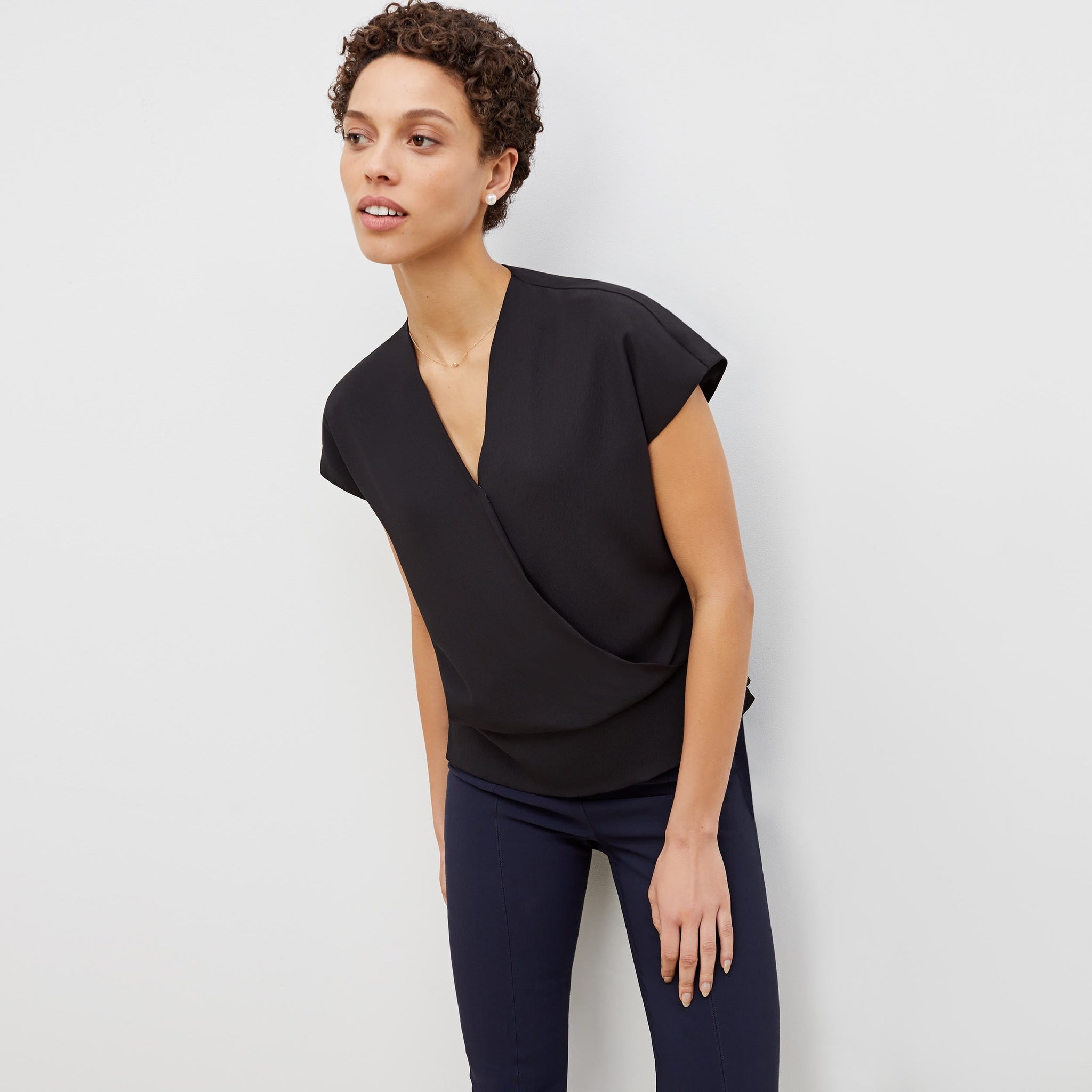 Front image of a woman standing wearing the antonia top soft wave in black