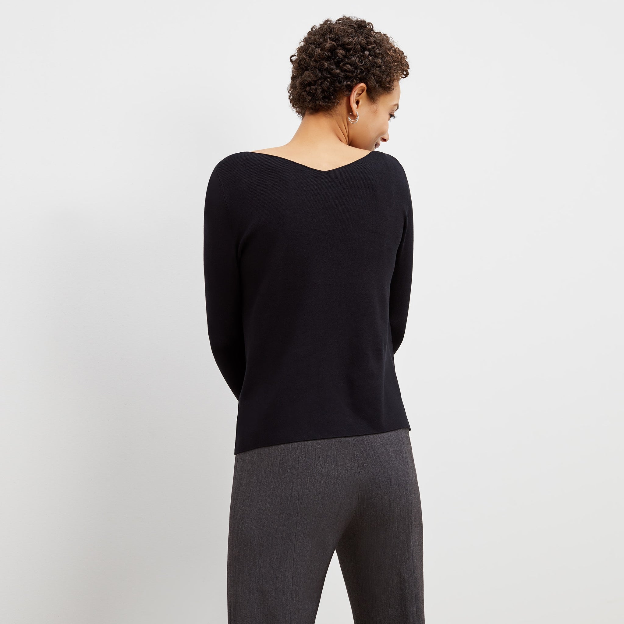 Back image of a woman standing wearing the celeste top in black