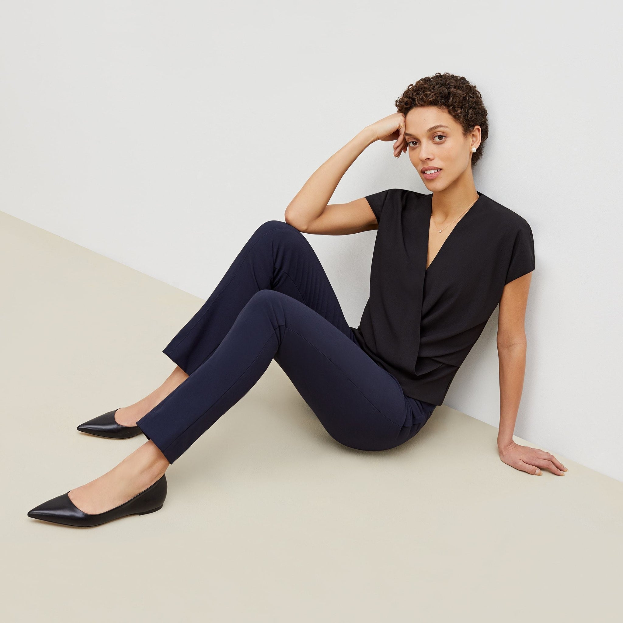 Front image of a woman standing wearing the foster pant in dark navy