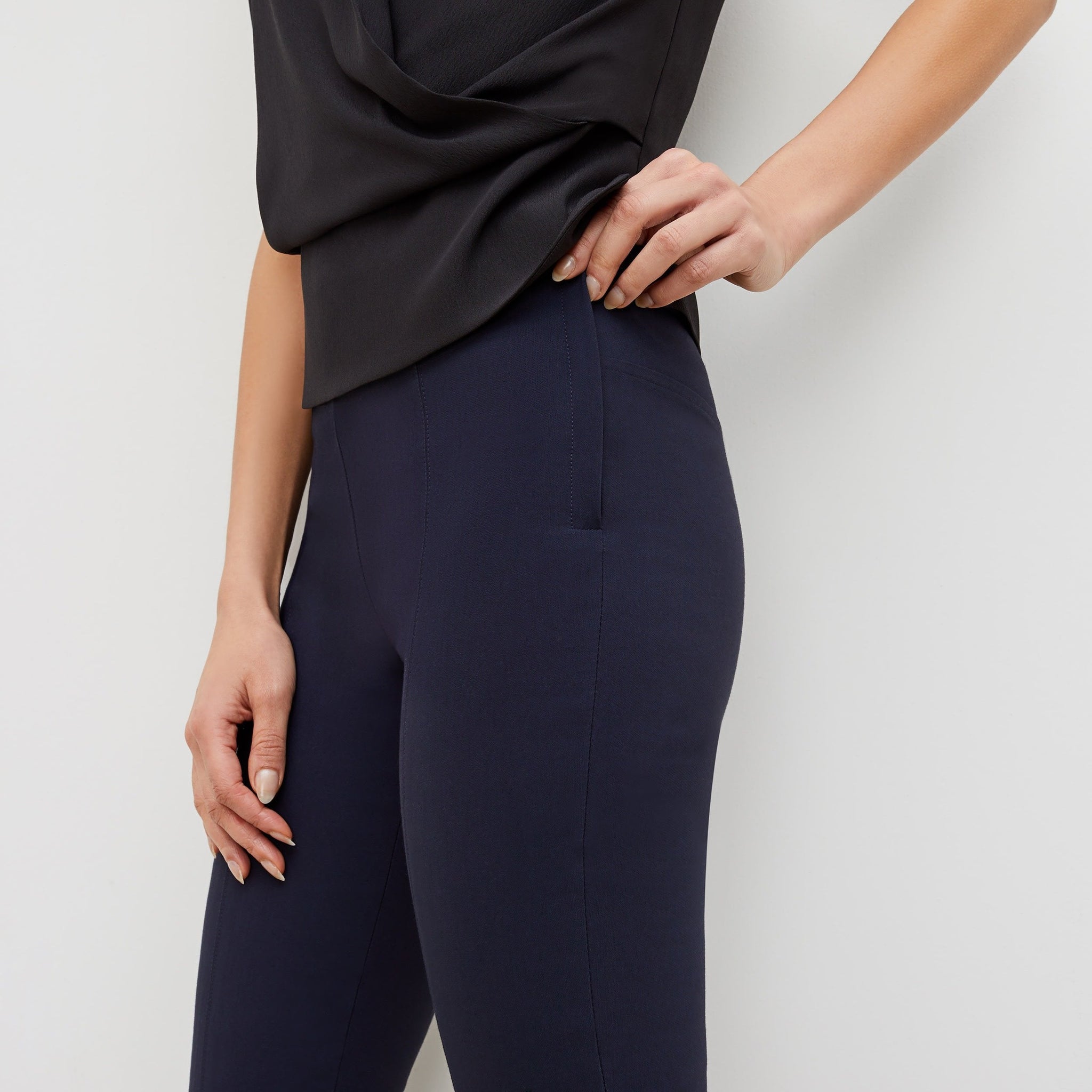 Side image of a woman standing wearing the foster pant in dark navy