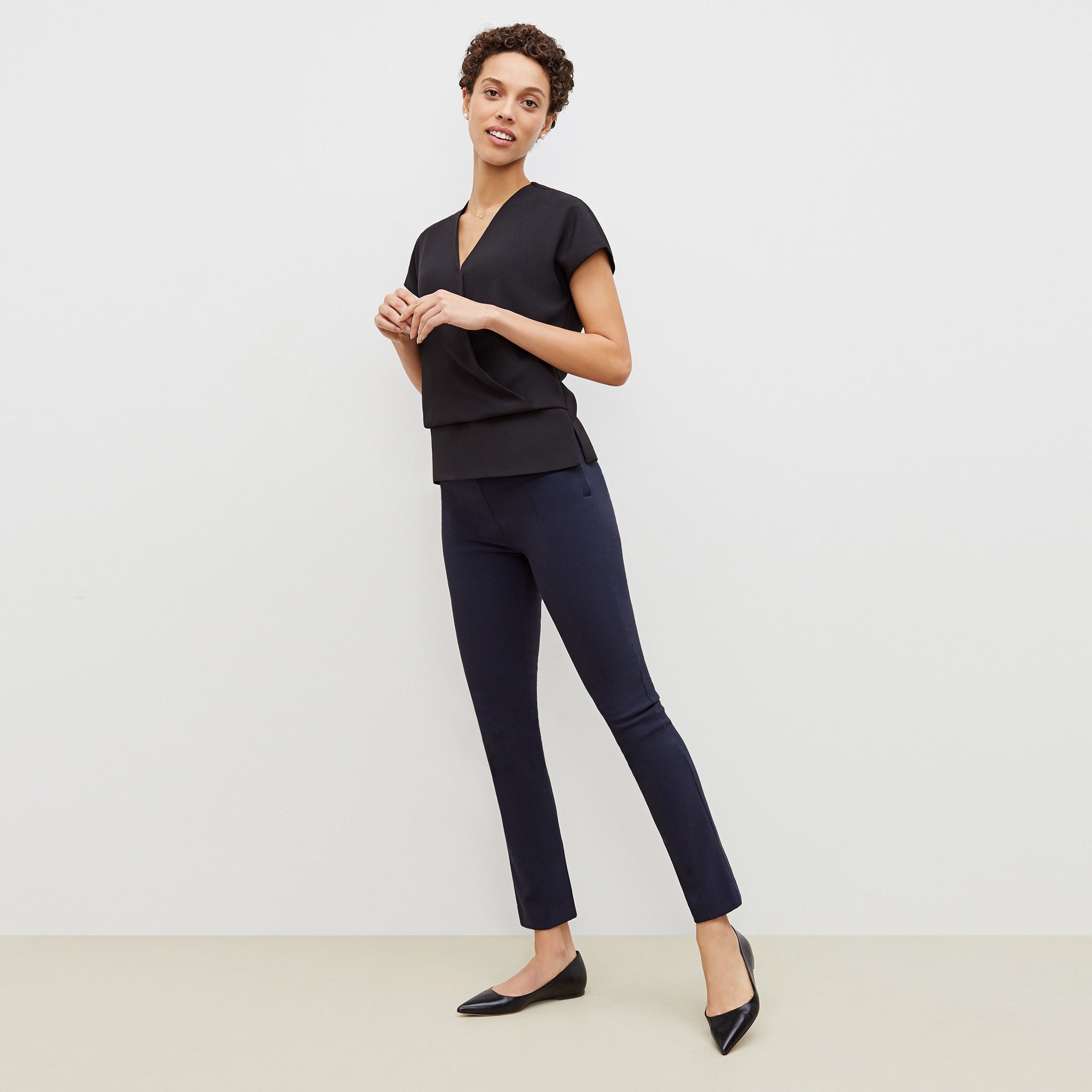 Front image of a woman standing wearing the foster pant in dark navy 