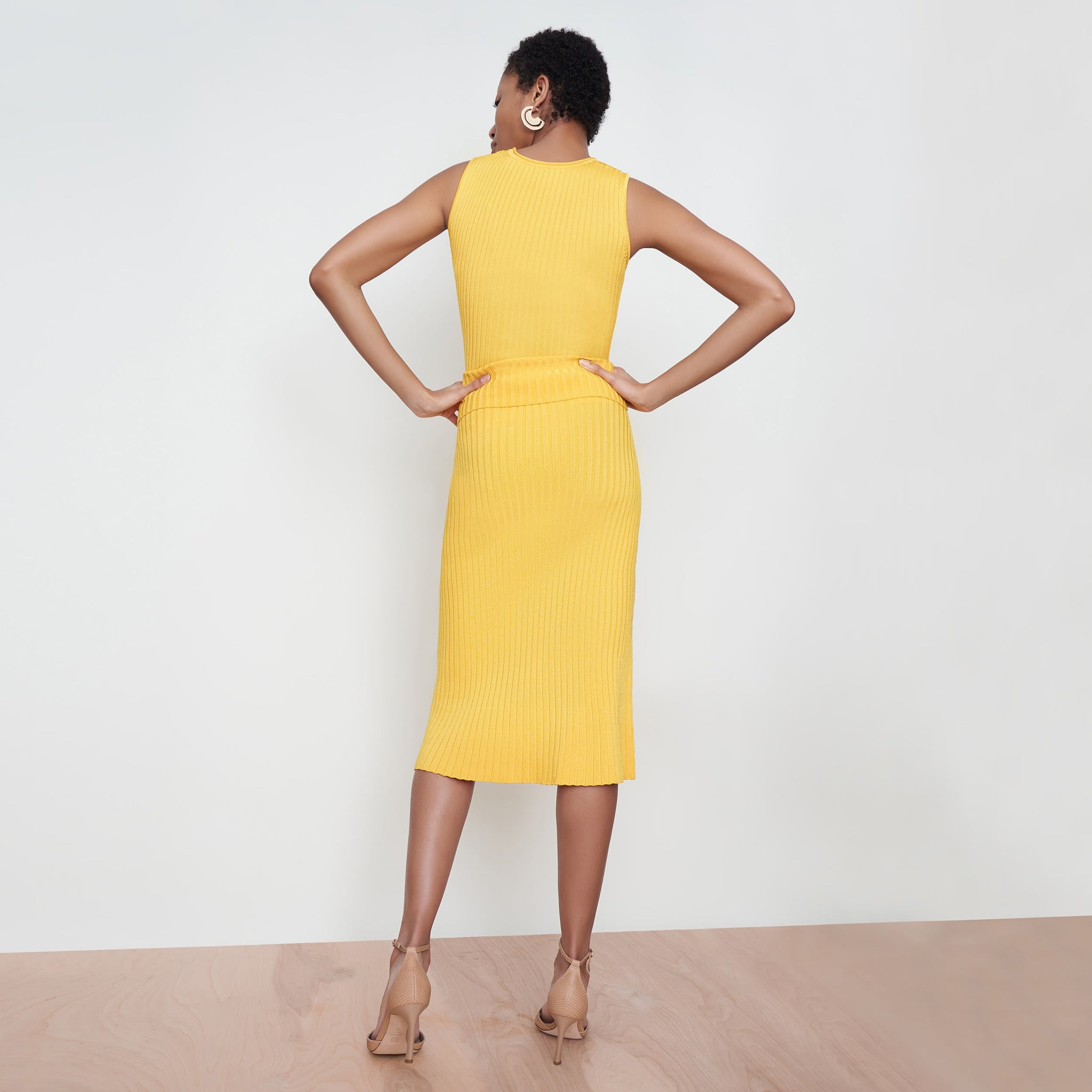 Back image of a woman standing wearing the York Skirt in Tuscan Yellow