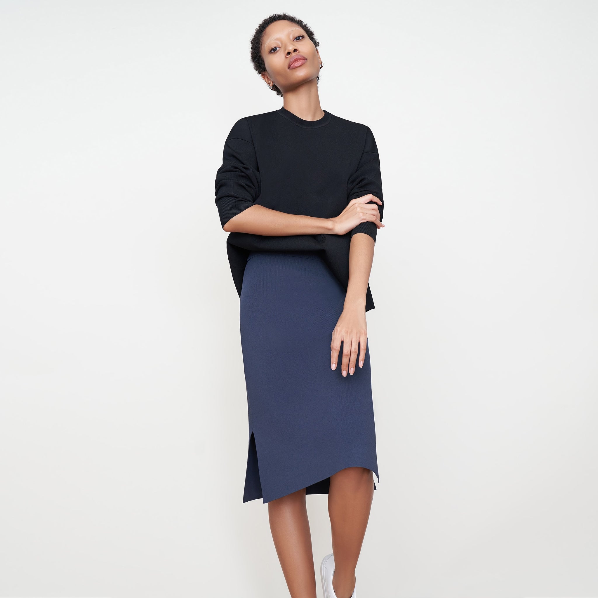 Front image of a woman standing wearing the Harlem skirt in jardigan knit in Baltic Blue