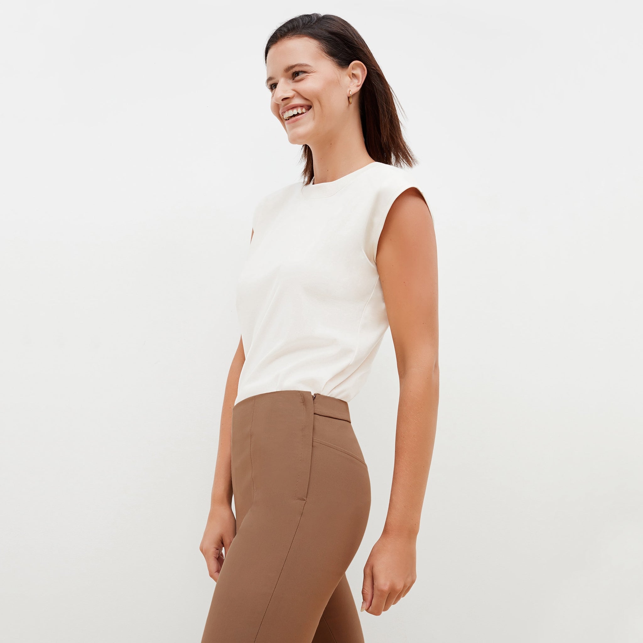 Side image of a woman standing wearing the alina top in compact cotton in ivory