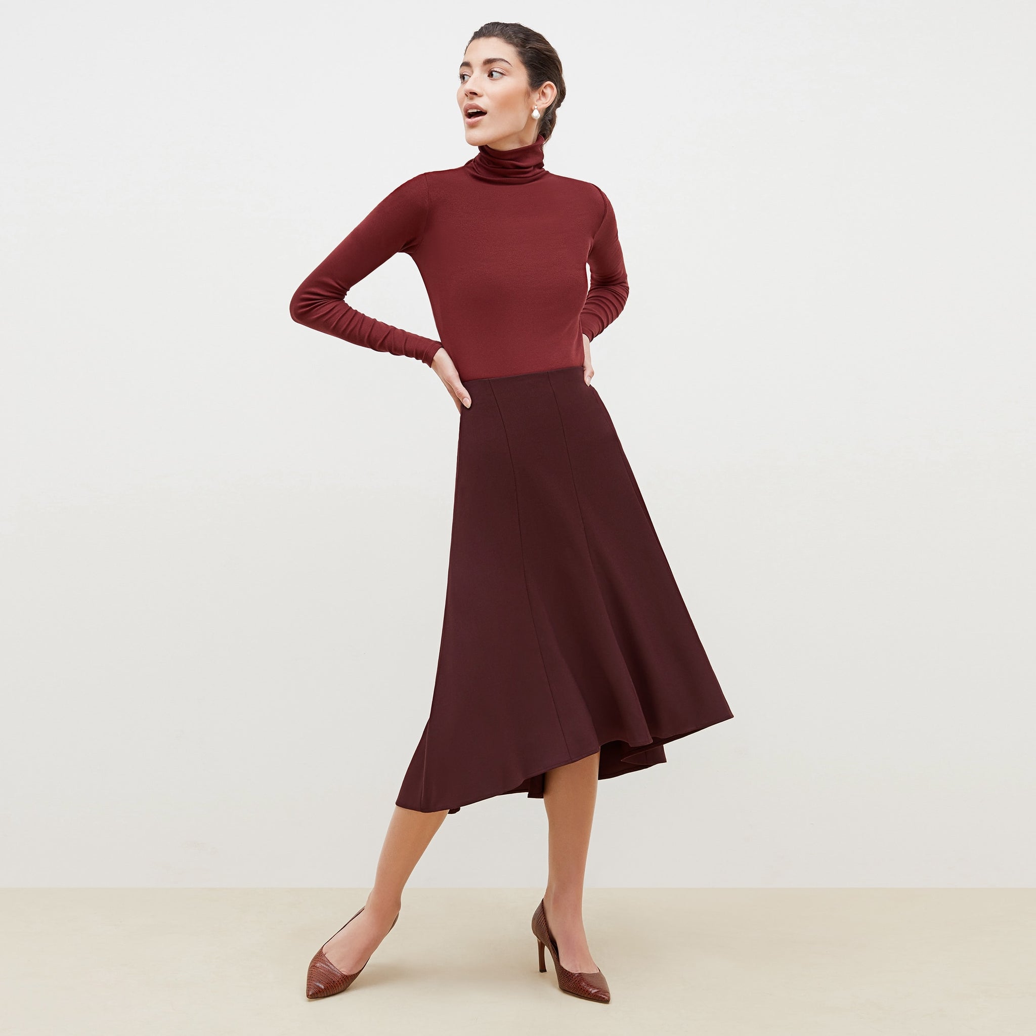 Front image of a woman standing wearing the axam top in cranberry 