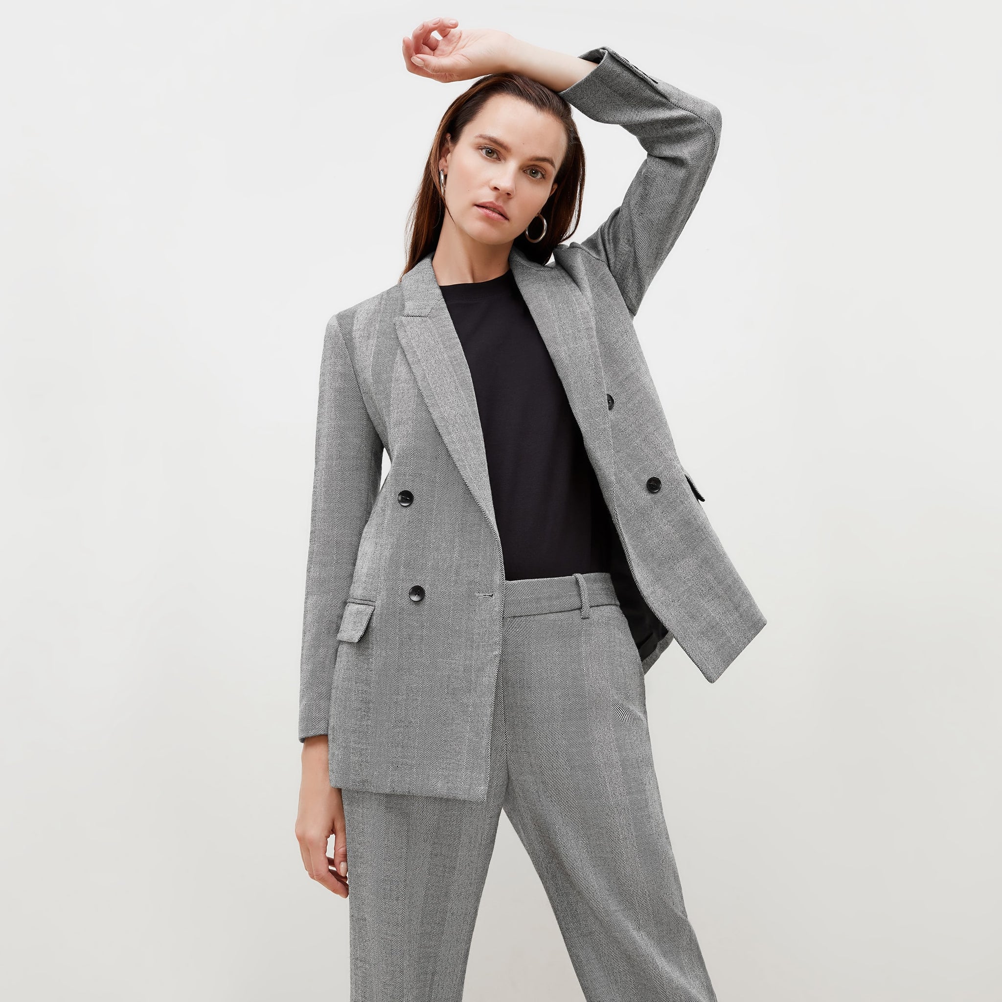 Front image of a woman standing wearing the o'hara blazer in wool herringbone in ivory and black