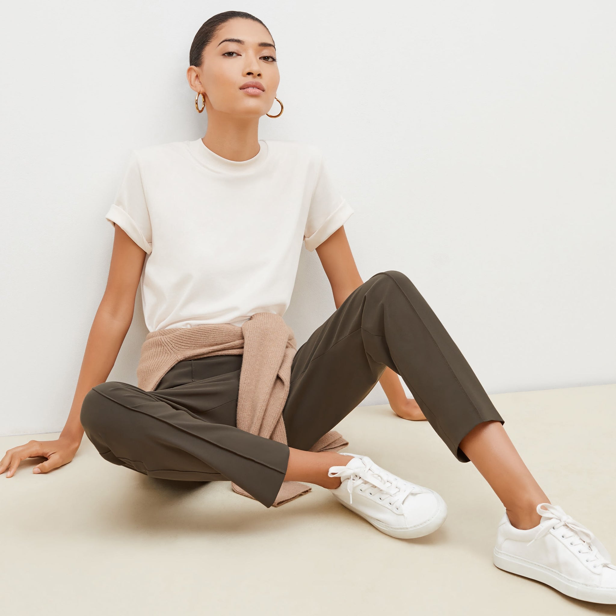 Front image of a woman sitting wearing the leslie top in compact cotton in ivory 