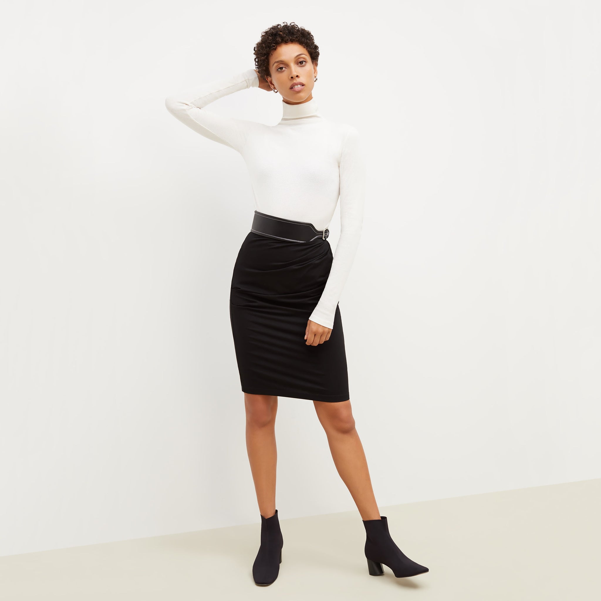 Front image of a woman standing wearing the soho skirt in black 