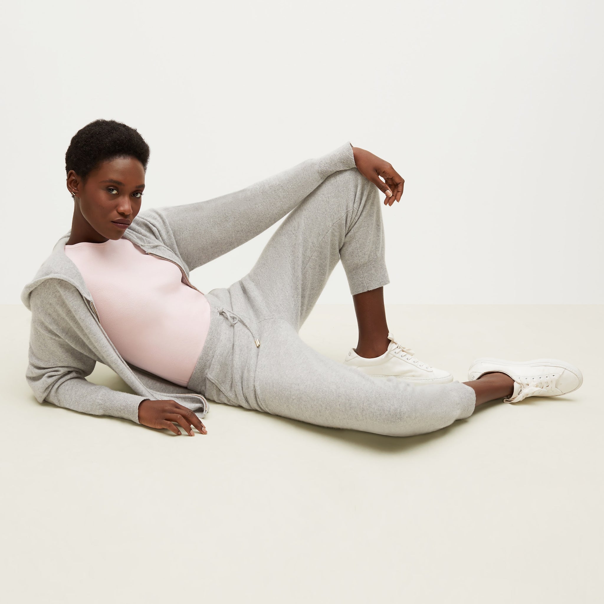 Side image of a woman lying down wearing the Choe Top—365Knit in Rosewater