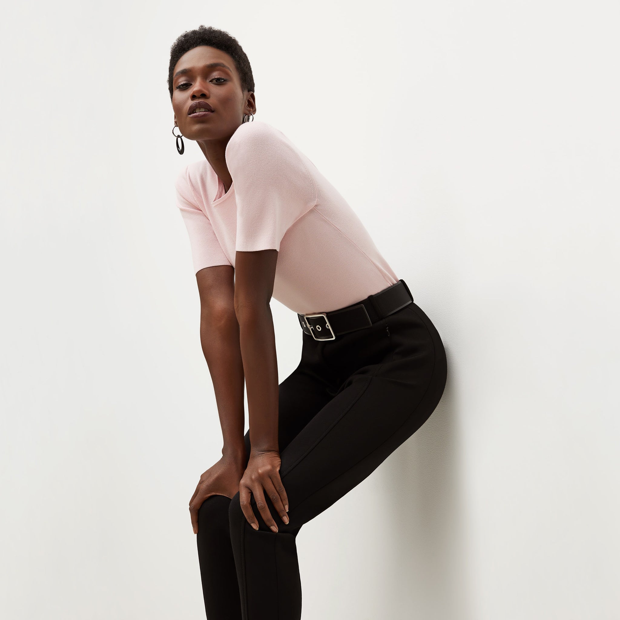 Side image of a woman standing wearing the Choe Top—365Knit in Rosewater