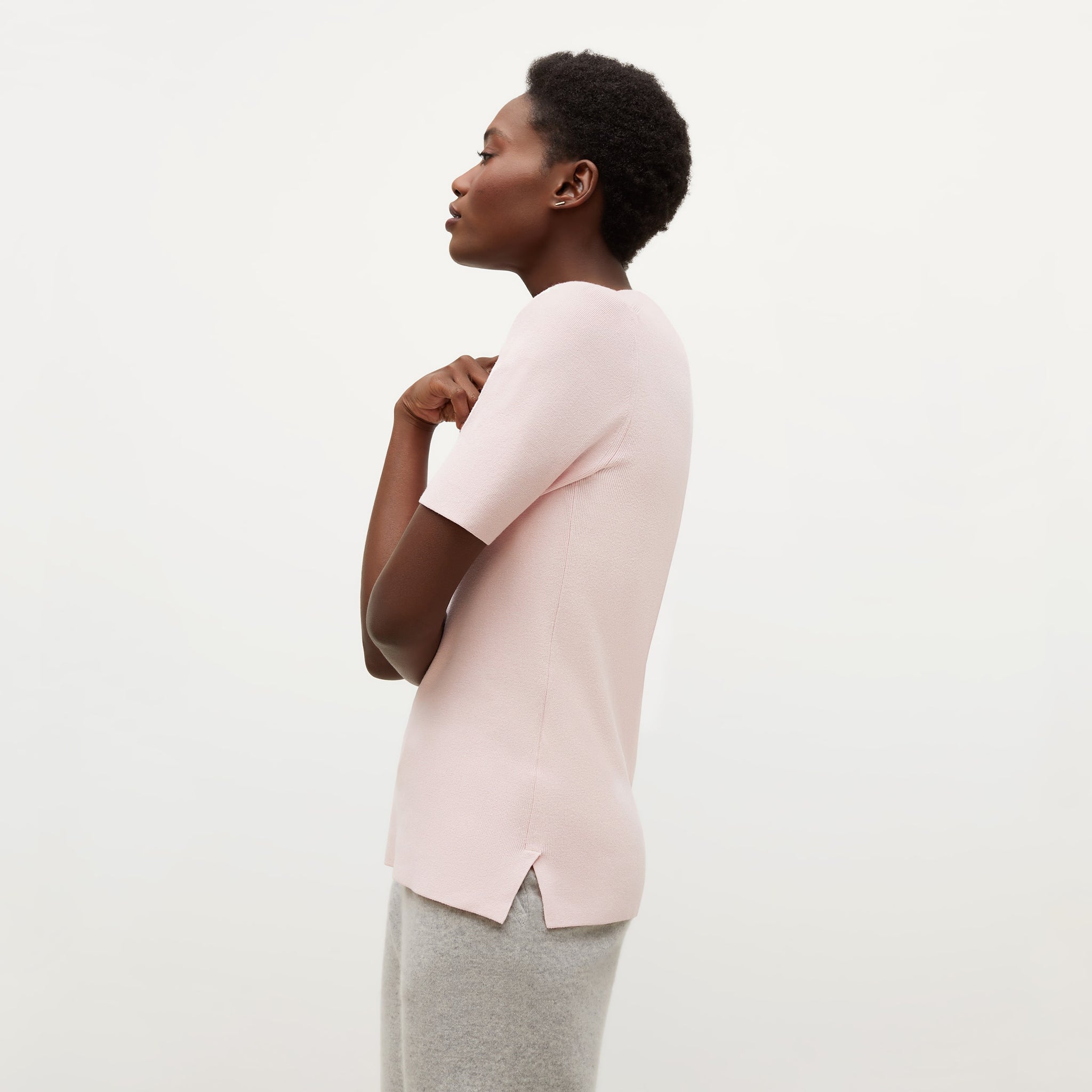 Side image of a woman standing wearing the Choe Top—365Knit in Rosewater